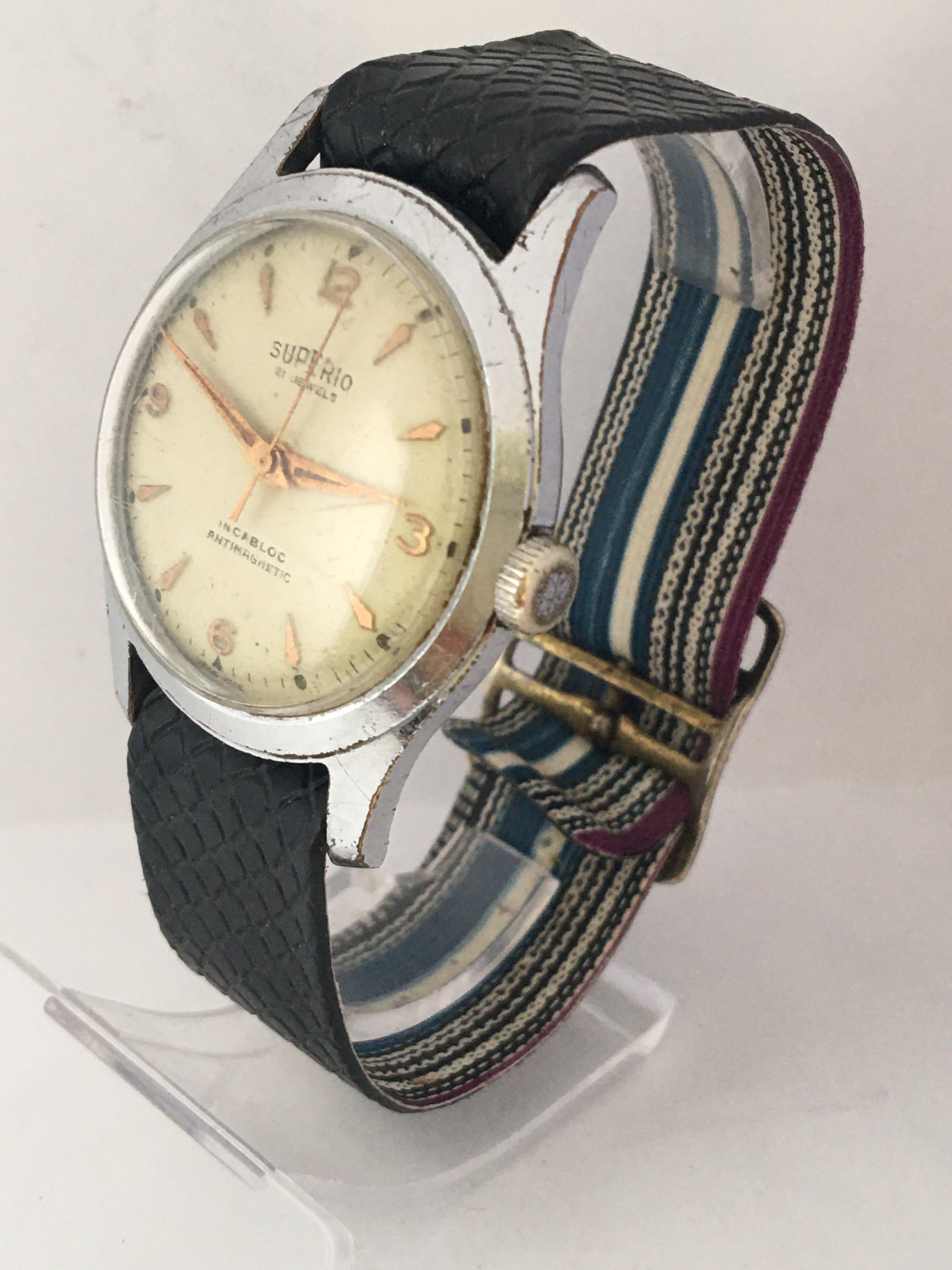 Cette charmante montre suisse vintage d'occasion à remontage manuel fonctionne et se porte bien. 
Cette montre présente des signes de vieillissement et d'usure avec de légères rayures sur le verre et son boîtier en métal argenté qui présente
