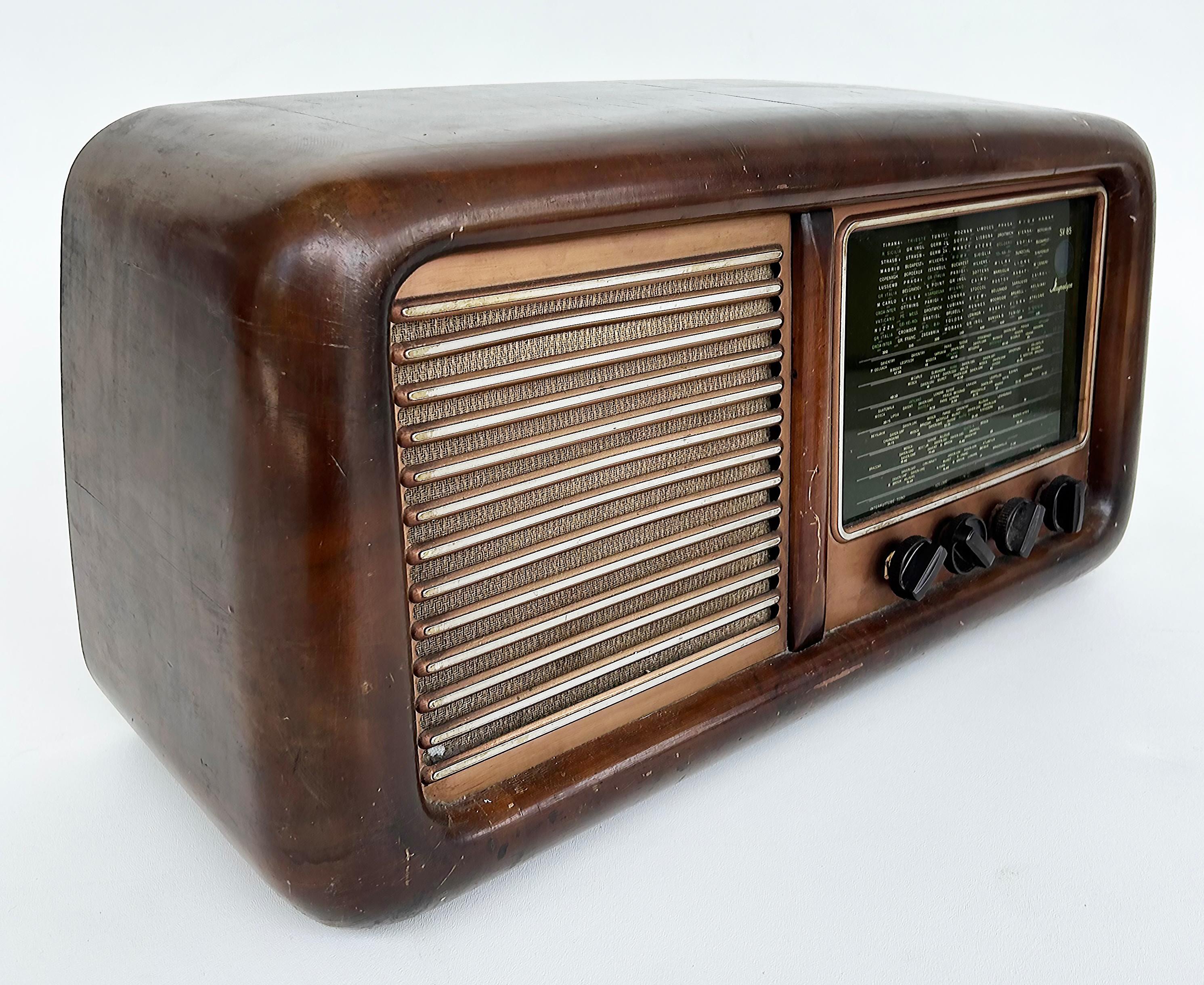 Radio Torino Model SV85 d'epoca degli anni '50 in legno, metallo e vetro

In vendita c'è una radio Magnadyne vintage degli anni '40-'50 proveniente da Torino, Italia.  Questa radio in legno, metallo e vetro ha una spina europea a tre poli, quindi