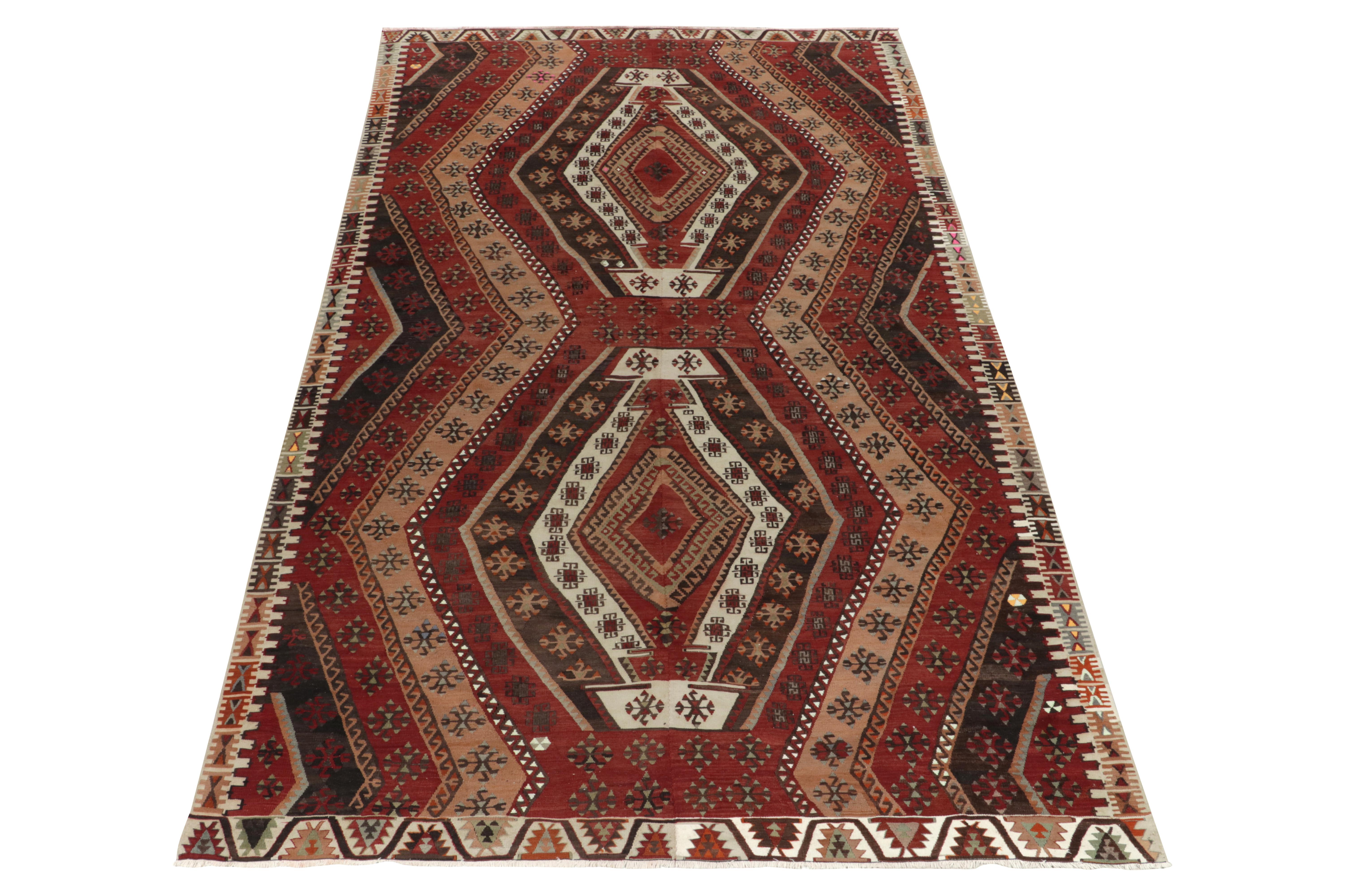 This 8x13 vintage tribal kilim rug remarks a prestigious addition in our flatweave collection. This particular mid-century flatweave from Turkey features a diamond pattern alternating in tones of red, beige, brown & white. From the 1950s, an