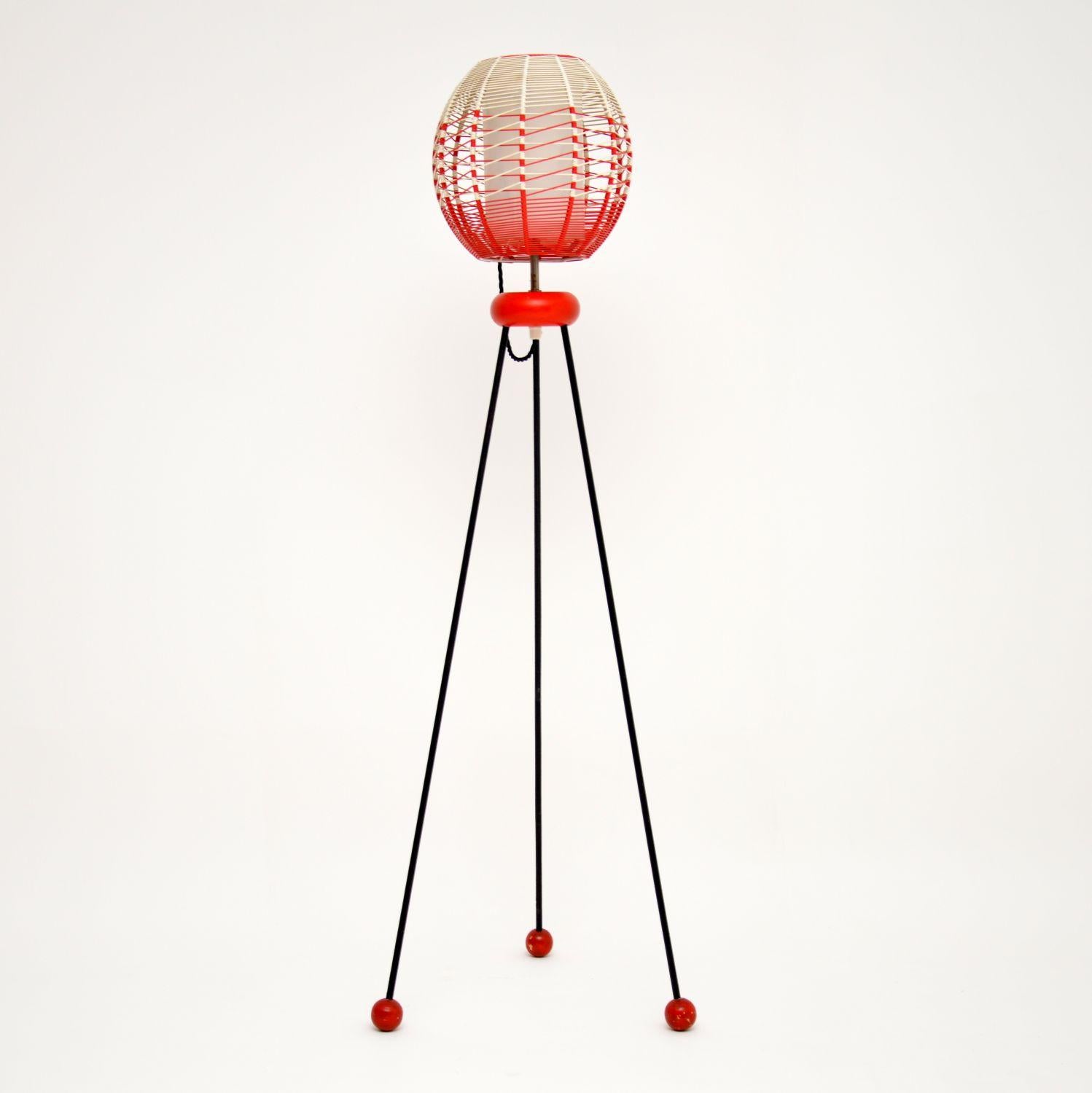 A stylish and unusual vintage floor lamp from the 1950s-1960s, this has an amazing atomic design. The shade is beautifully spun from colored plastic cord, the legs are steel and can be unscrewed easily from the wooden fixture. The condition is