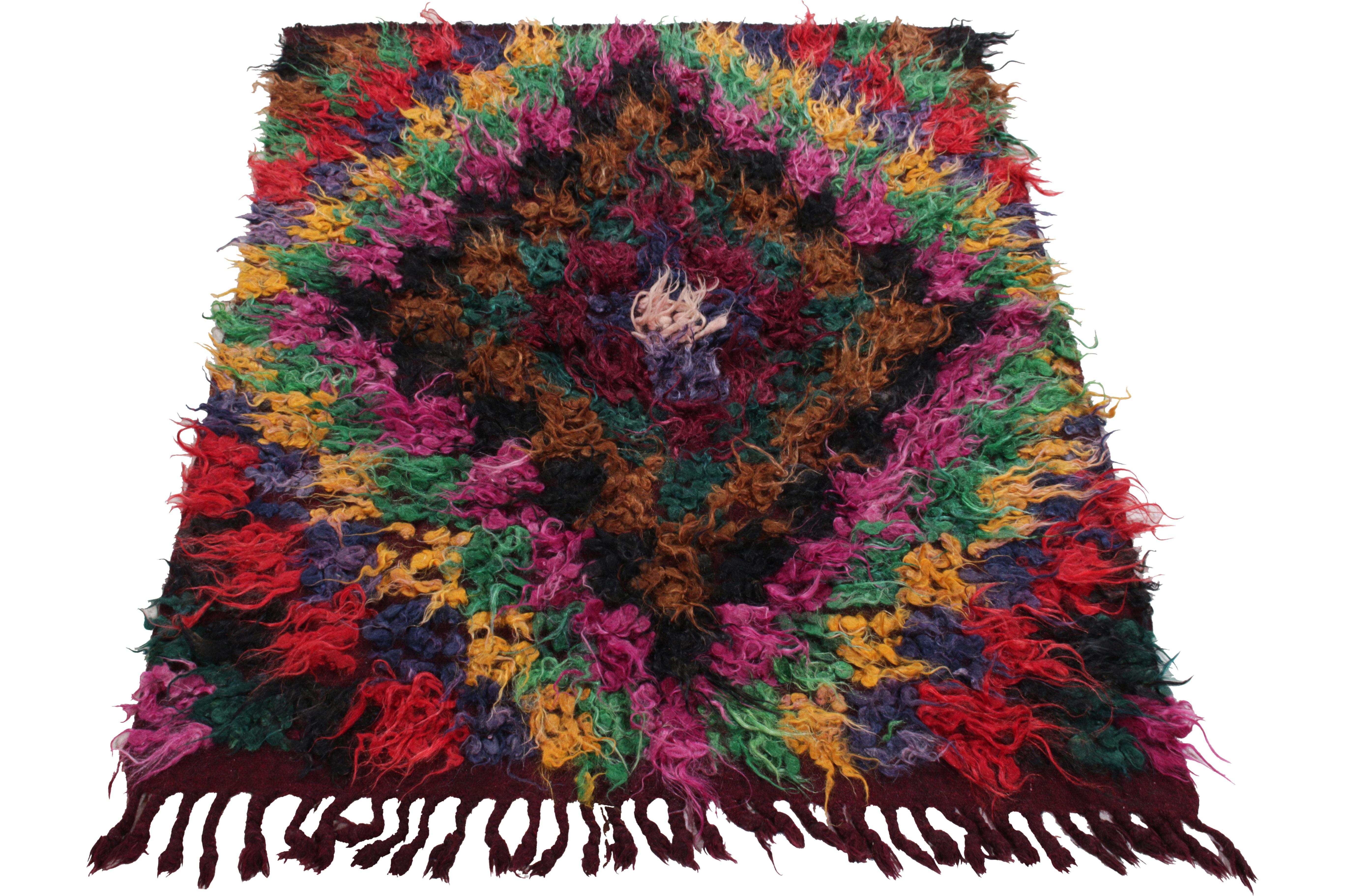 Coming from Turkey circa 1950-1960, this 4x5 vintage shag rug enjoys a resplendent high pile in magenta, forest green, golden, ink blue, red, back & chocolate brown - all springing from white in the centre. The shaggy appearance plays whimsically
