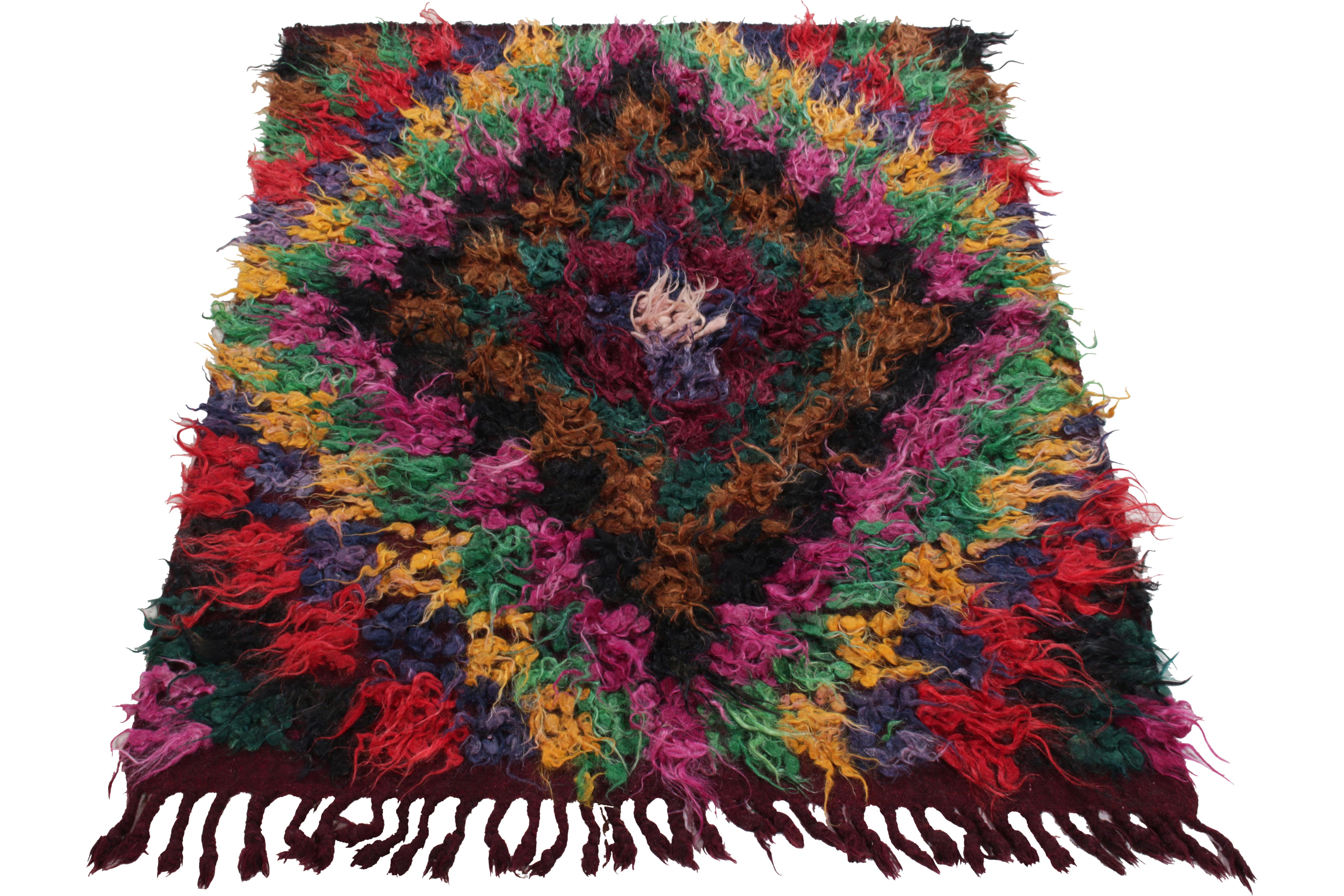 Dieser um 1950-1960 aus der Türkei stammende 4x5 Zottelteppich hat einen prächtigen Hochflor in Magenta, Waldgrün, Gold, Tintenblau, Rot, Rücken und Schokoladenbraun, der in der Mitte von Weiß ausgeht. Das zottelige Erscheinungsbild spielt auf