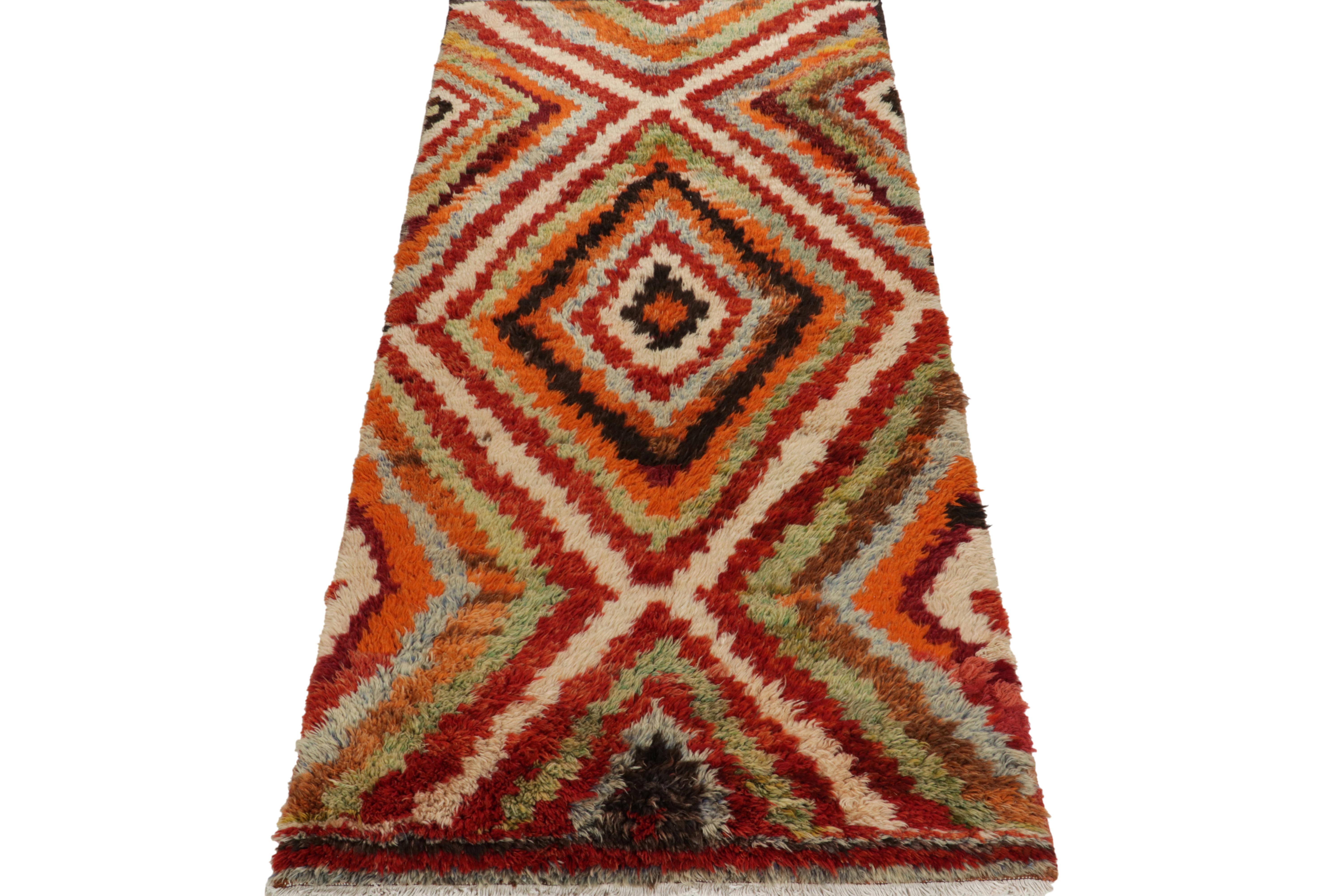 Hand-knotted in wool, a 4x10 vintage Tulu runner originating from Turkey circa 1950-1960, now joining Rug & Kilim’s Antique & Vintage collection. 

On the Design: The healthy shag pile enjoys a rare tribal geometric pattern in orange, red, white &