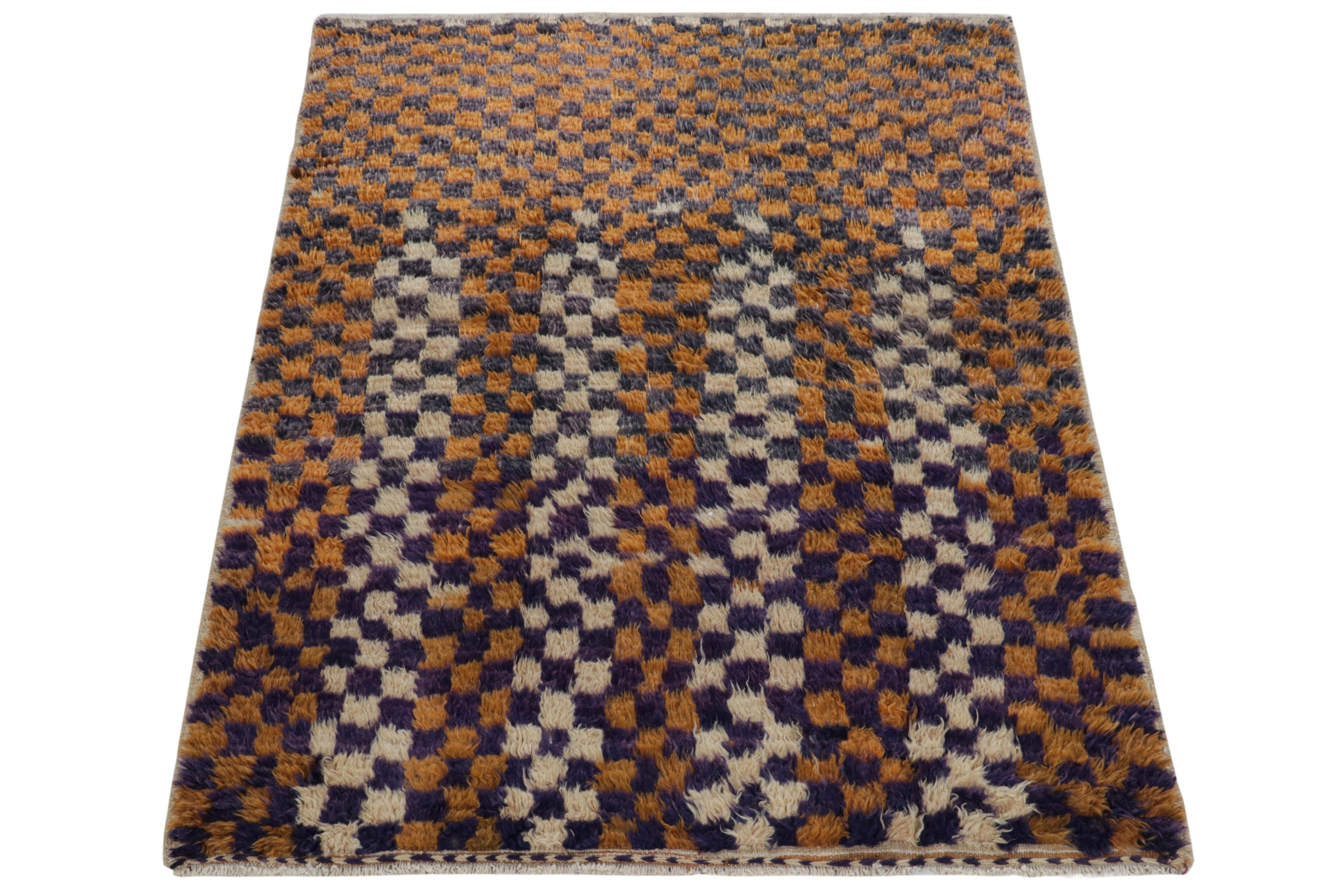 Hand-knotted in wool, a 5x7 vintage Tulu rug originating from Turkey circa 1950-1960, now joining Rug & Kilim’s classic tribal collection. The healthy high pile features a well defined checkered pattern in ink and midnight blue, with marigold tones