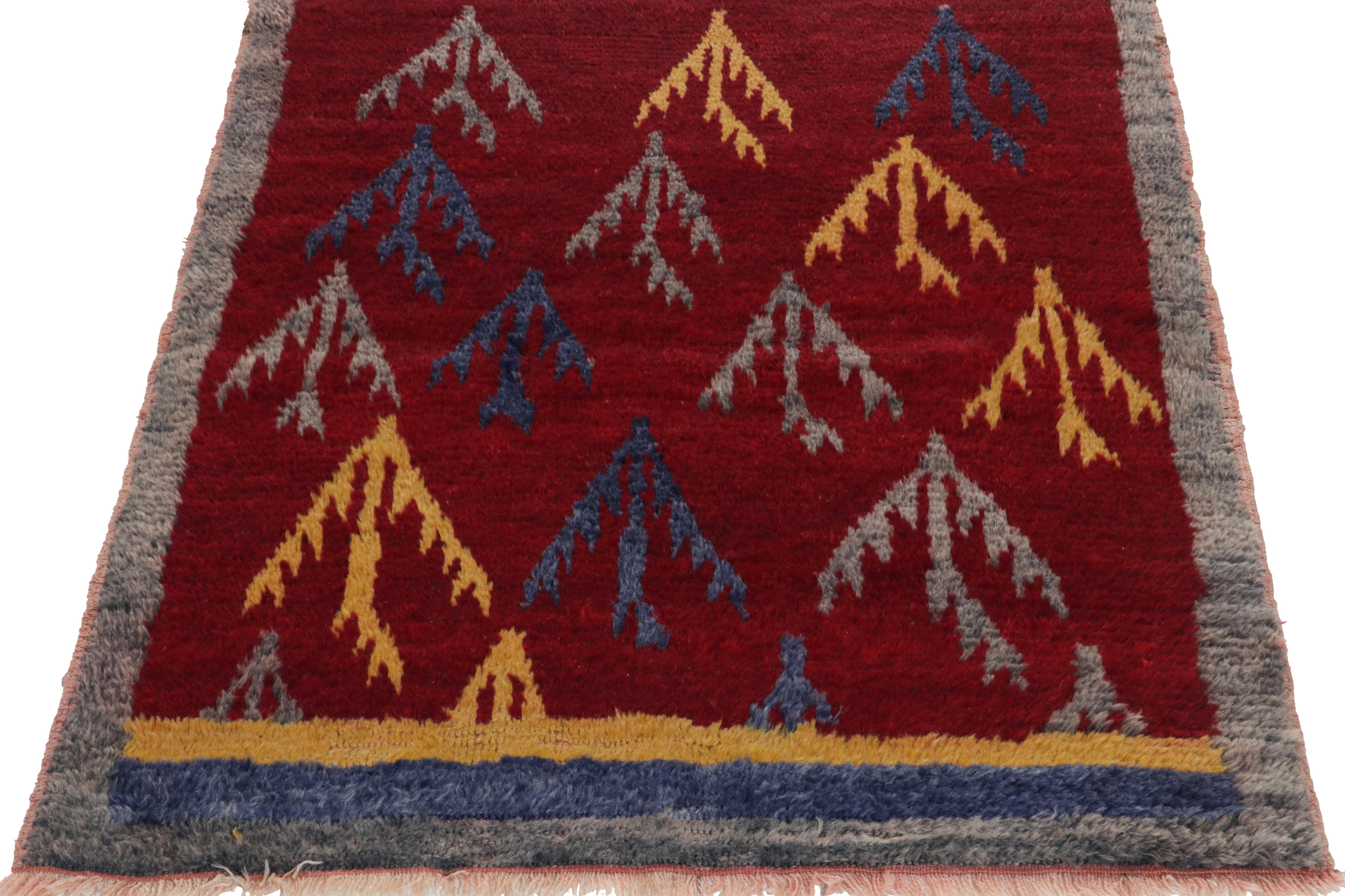 A 3x4 vintage Tulu shag rug from Turkey entering Rug & Kilim’s Antique & Vintage collection featuring sharp tribal motifs in yellow, grey & blue on a luscious red backdrop. The rug further enjoys slate gray on the border with fine fringes in white &