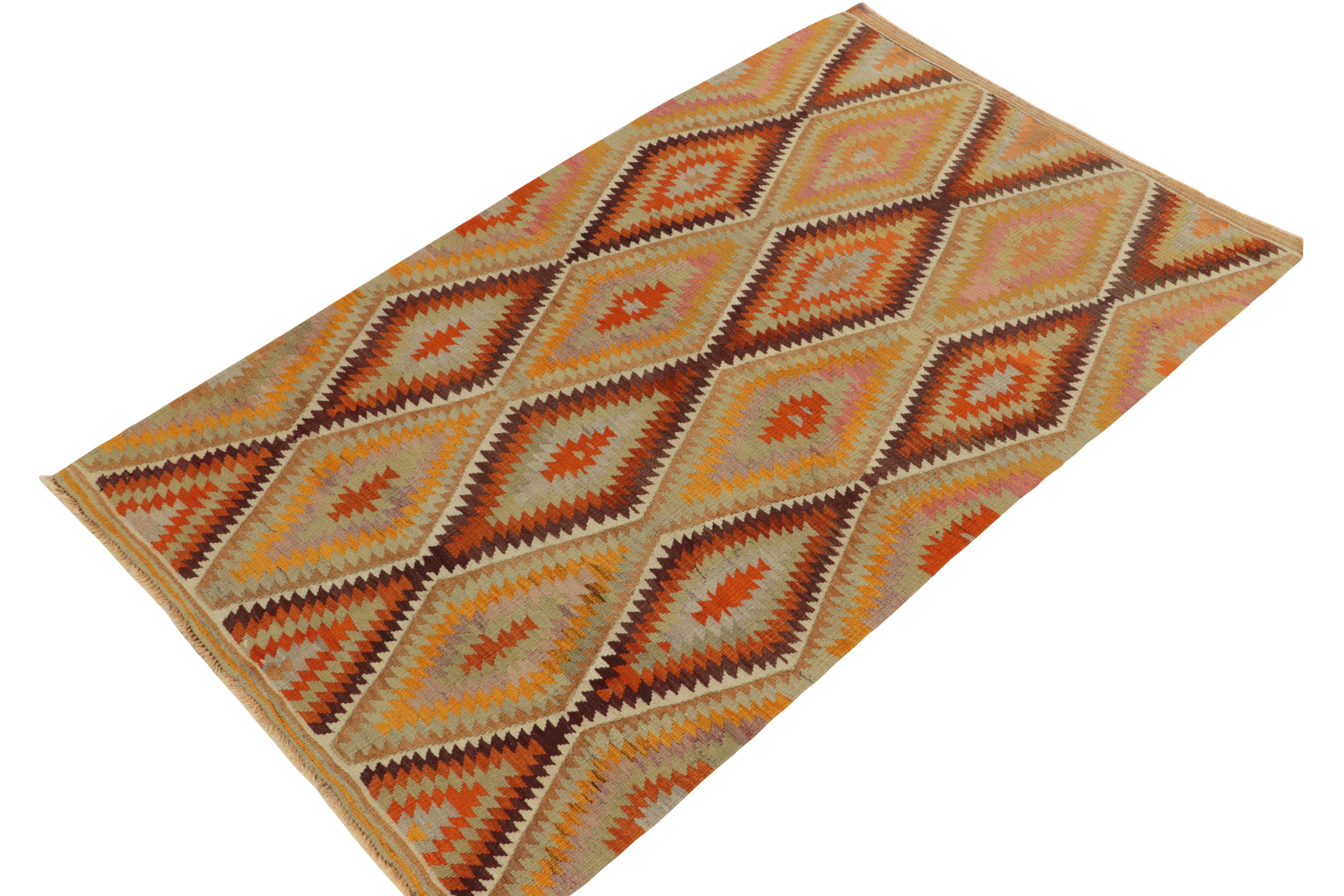 Originating from Turkey circa 1950-1960, a 5x7 vintage Turkish kilim rug exemplifying mid-century tribal sensibilities. 

Handwoven in wool, the sharp geometric pattern revels in warm orange & gold tones sitting beautifully with pastel pink & teal