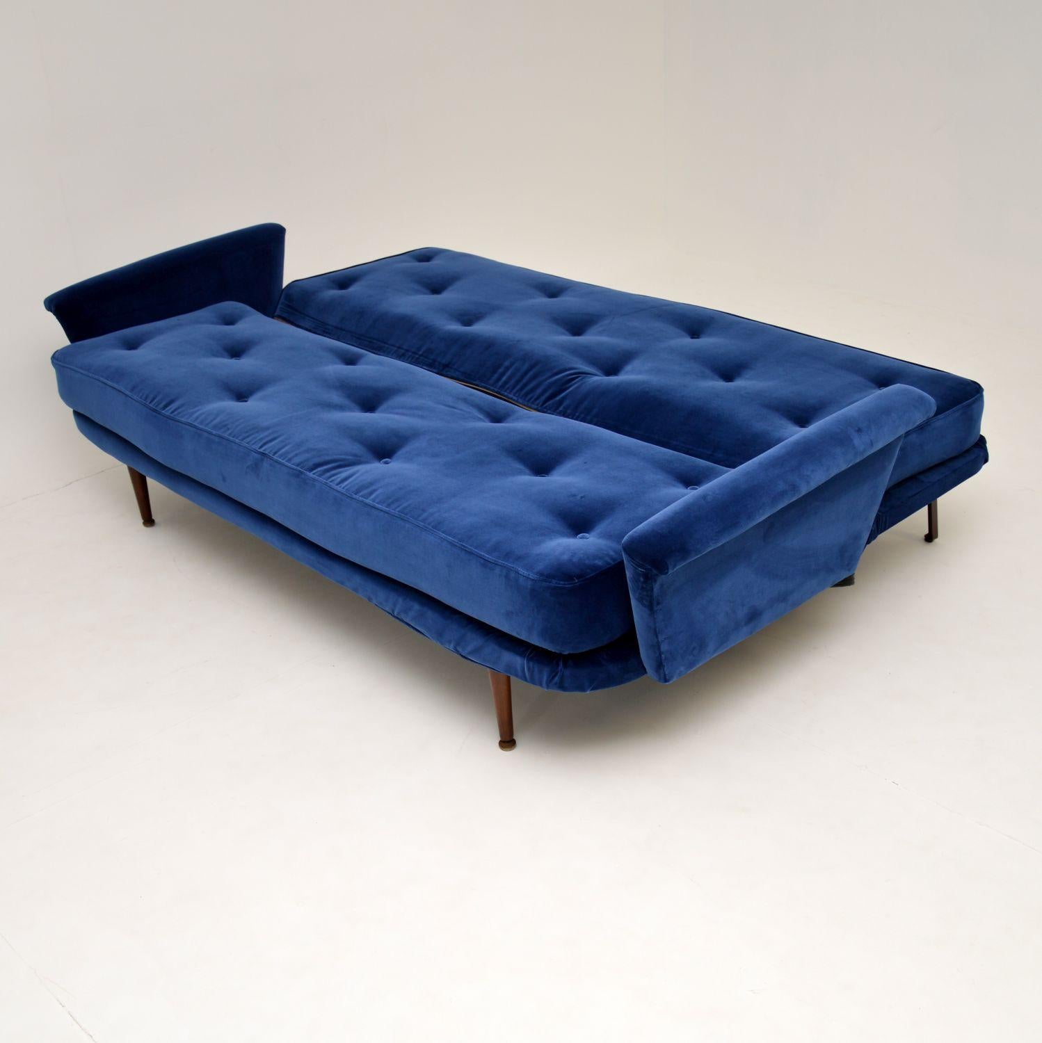 A beautiful, very well made and extremely comfortable vintage sofa bed. This dates from the 1950s, it has a beautiful design.

We have had this completely re-upholstered in a beautiful royal blue velvet fabric, the condition is superb for its