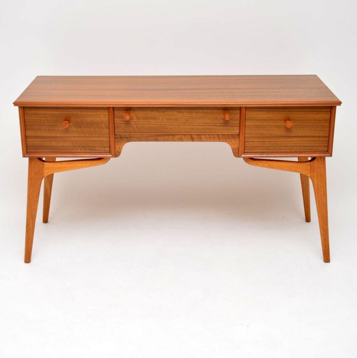 A stylish and practical vintage desk in walnut, this was made by the high end manufacturer Alfred cox, it dates from the 1950s-1960s. The quality is superb, we have had this stripped and re-polished to a very high standard, the condition is