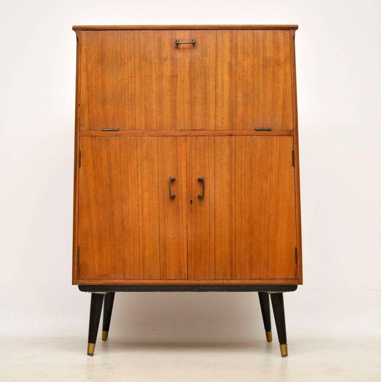 A stylish and practical vintage drinks cabinet in walnut, this dates from the 1950s-1960s. It’s in excellent condition for its age and is really well made, there is just some very minor surface wear here and there. The top opens out to reveal a