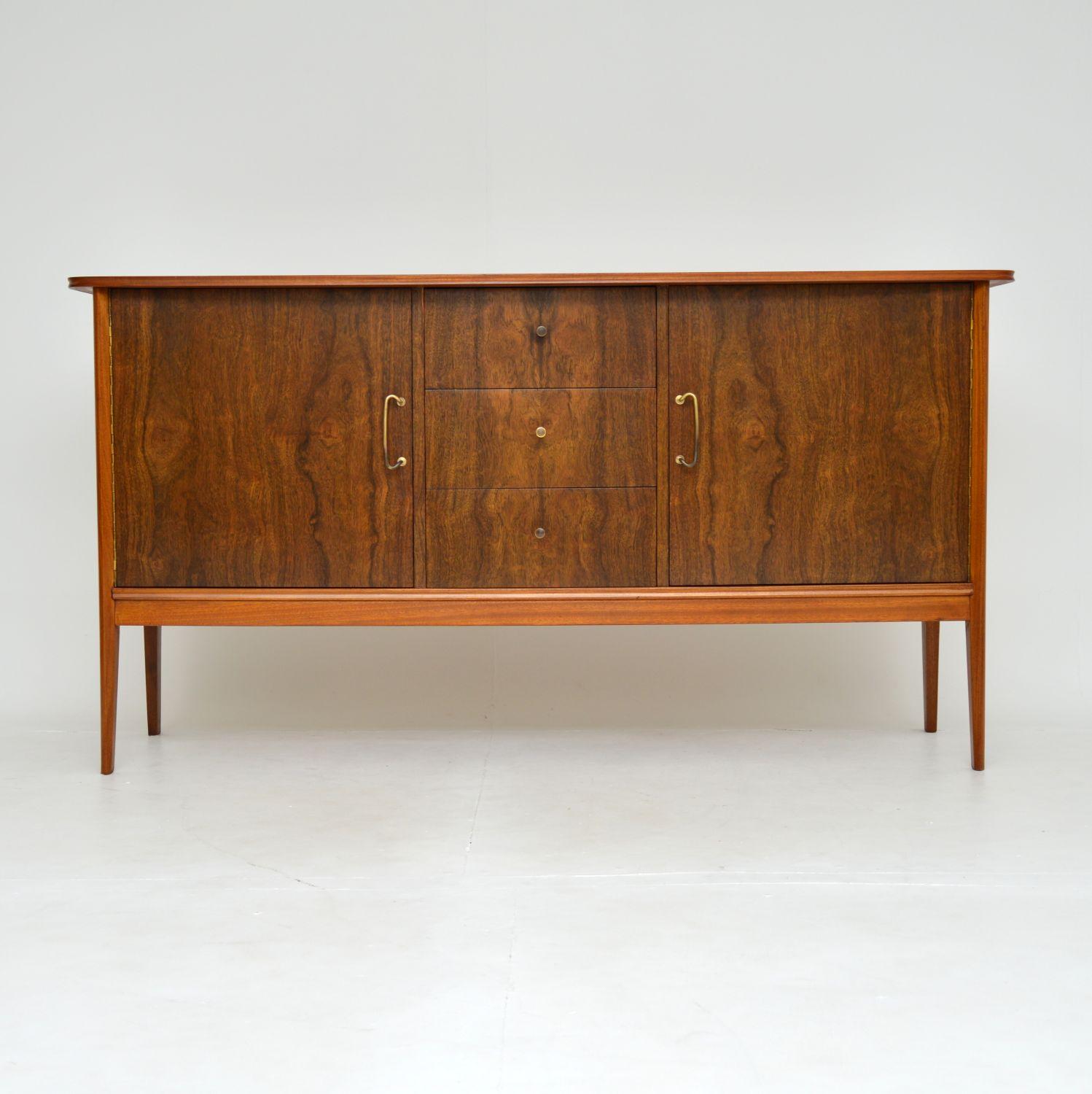 A stylish and extremely well made vintage sideboard in walnut. This was designed by Peter Hayward, it was made in England by Vanson, and it dates from the 1950-1960’s.

The quality is outstanding, this is made from a combination of solid walnut,