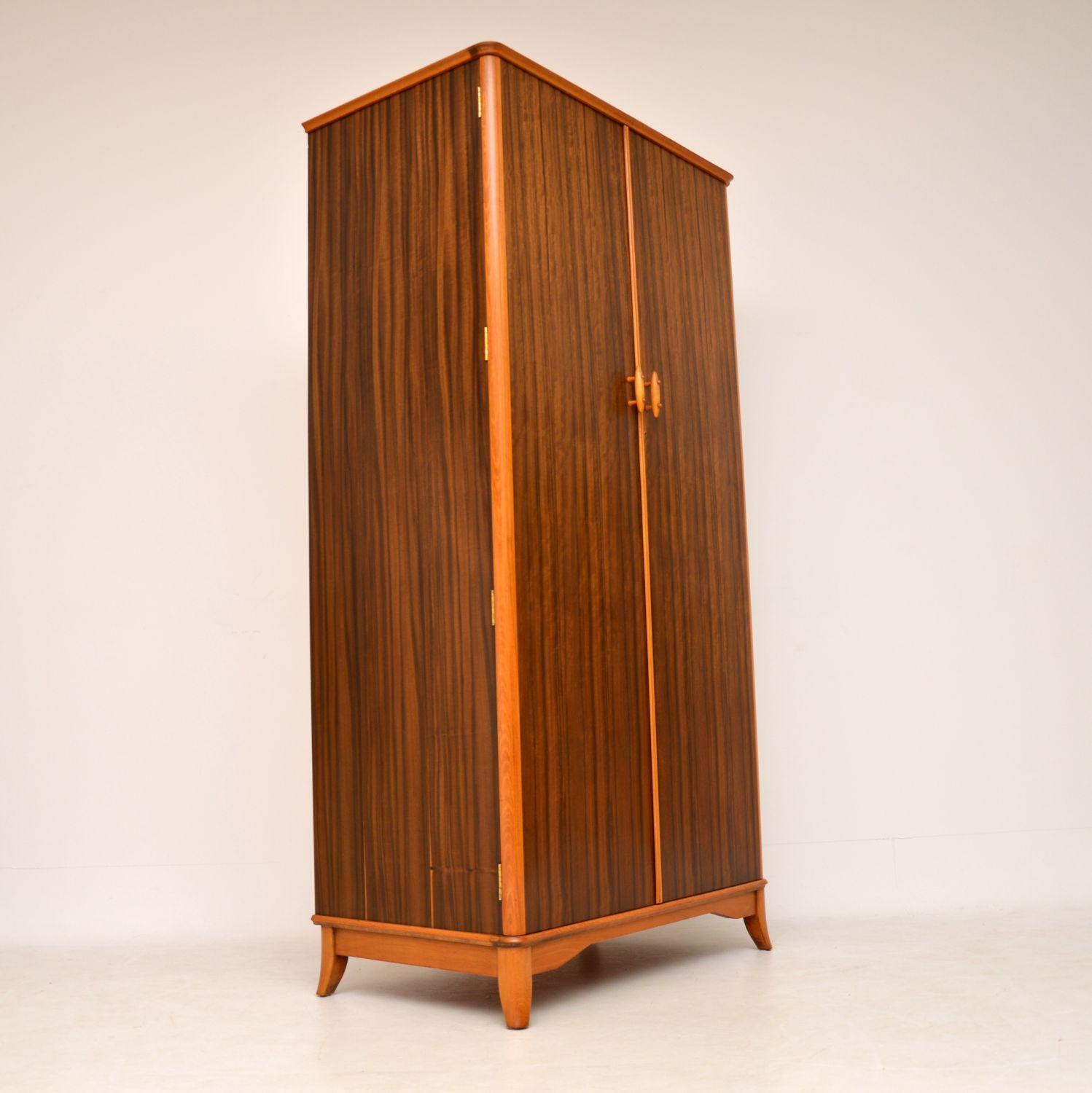 A stunning vintage wardrobe in walnut and contrasting beech, this was made by Vesper furniture in England during the 1950s-1960s. It is of amazing quality, with lots of nice features. The walnut has a beautiful colour and grain patterns, the handles