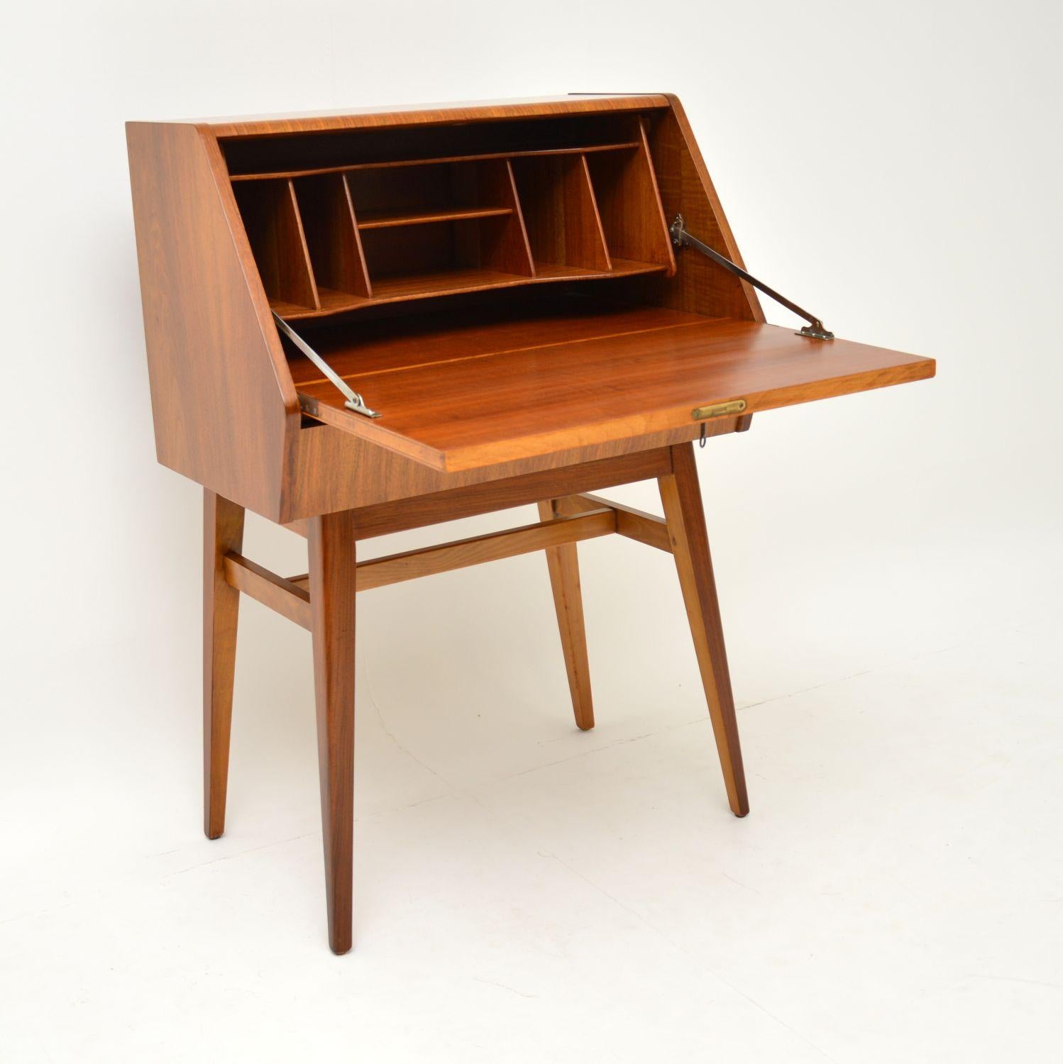 A stunning vintage bureau in walnut, this dates from the 1950s-1960s. It is of super quality, with a beautiful angular design. There is a locking key, a lower drawer and this has ample writing/storage space for such an elegant compact design. We