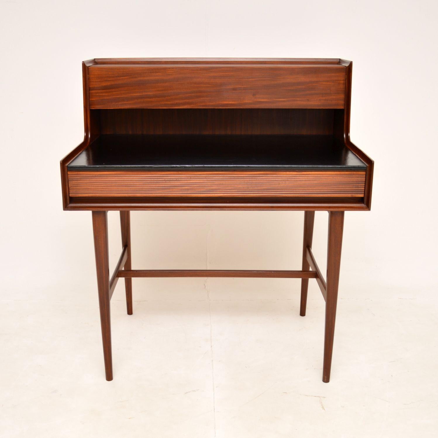 A fantastic vintage writing desk in solid wood. This was designed by Richard Hornby for Fyne Ladye, it was made in England around the 1950-60’s.

The quality is amazing, this has a stylish and very practical design. It is elegant yet very study,