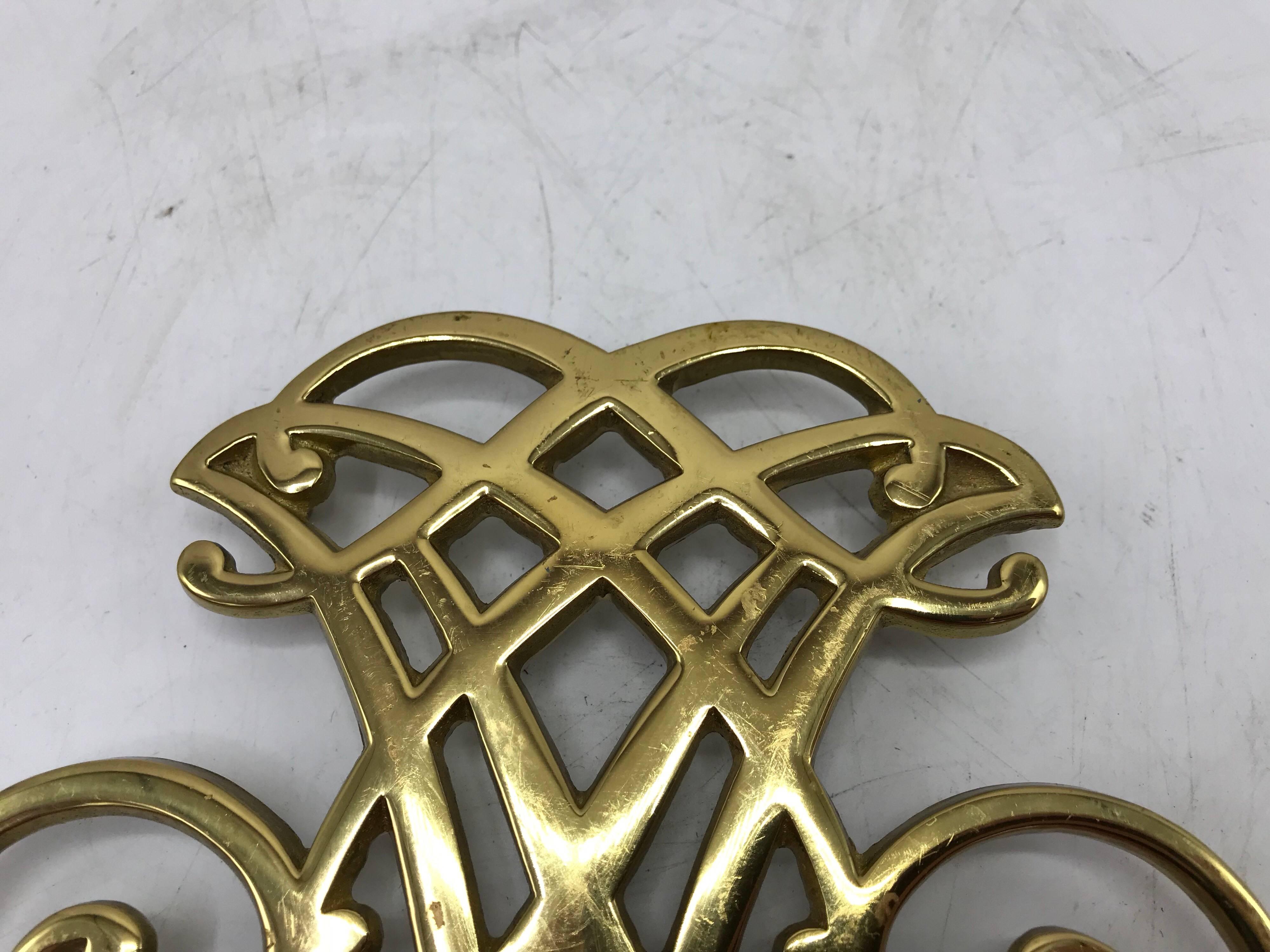 Offered is a beautiful, 1950s solid-brass Virginia Metalcrafters Thomas Jefferson Monticello Cypher trivet. Marked on backside with Virginia Metalcrafters signature 'VMC' stamp. Heavy.

“Since 1890, the Virginia Metalcrafters hallmark has become