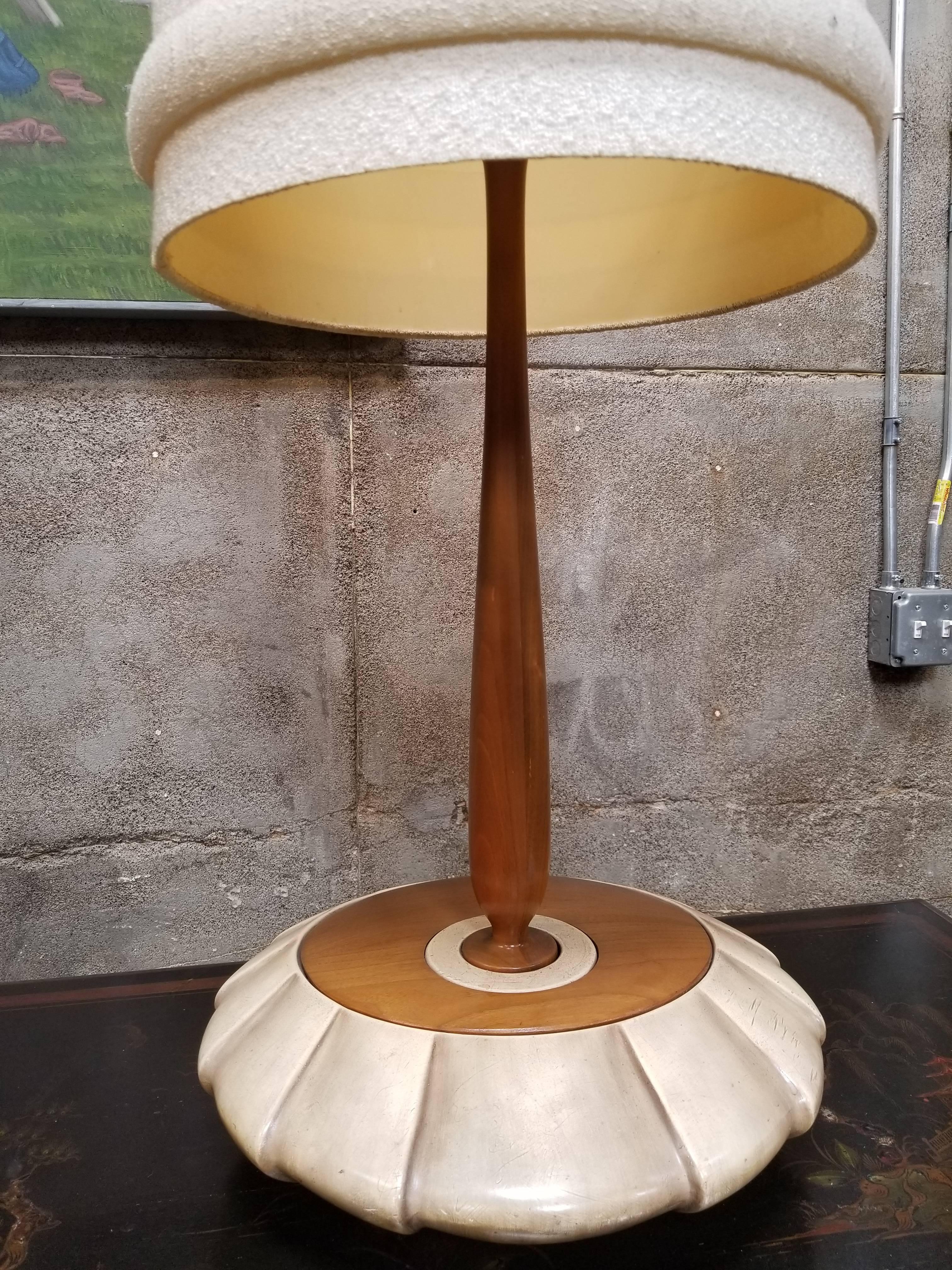 Unusual dimensions to this walnut and painted plaster table lamp. Large ovoid base with an off-set circular design. Original shade included, circa 1950s. 