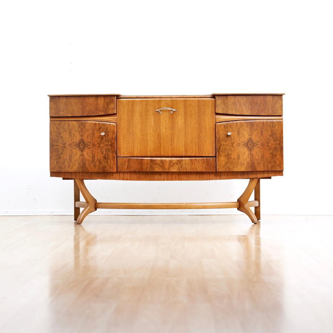 Diese Cocktailschrank-Credenza aus der Mitte des Jahrhunderts wurde in den 1950er Jahren von Beautility Furniture in England entworfen und hergestellt. Ein fantastisches Vintage-Stück mit viel Stauraum in drei neu mit Filz gefütterten Schubladen,