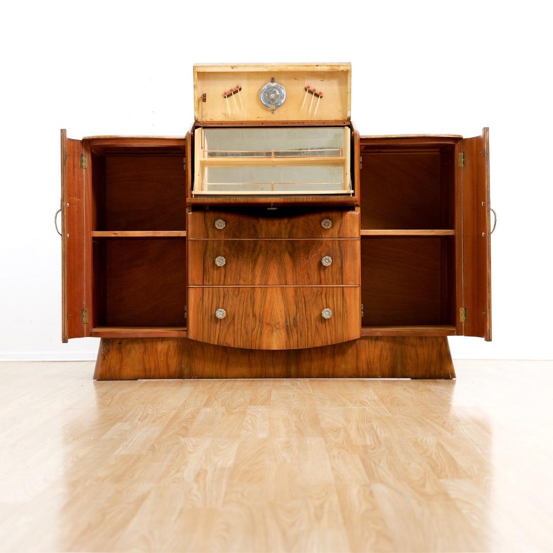 Questa credenza vintage di metà secolo è stata progettata e prodotta da Nathan Furniture in Inghilterra negli anni Cinquanta. Si tratta di una credenza di grande effetto e dal design elegante, con una bellissima venatura frontale in noce.  Il mobile