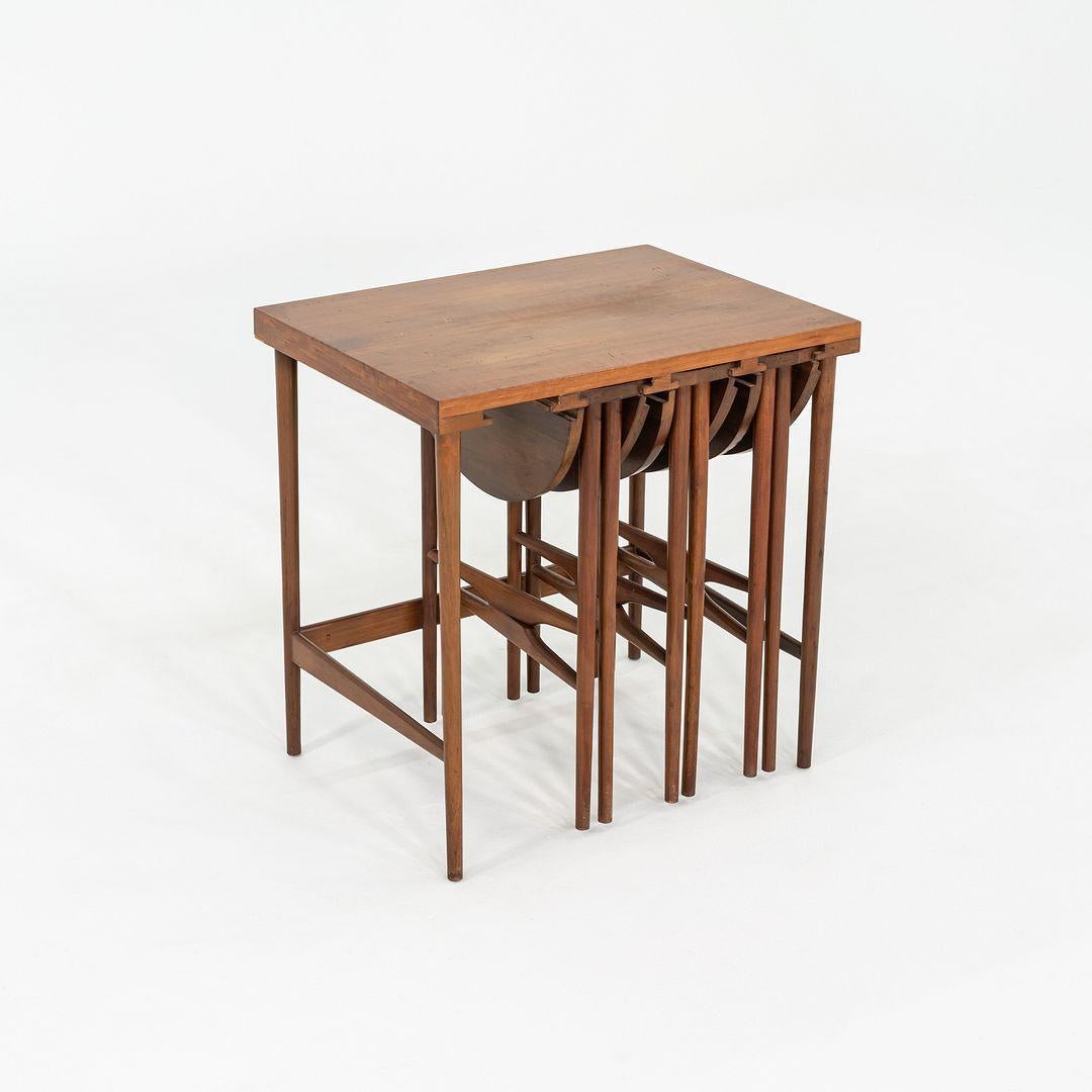 Este es un bonito juego de mesas auxiliares de nogal aceitado, diseñado por Bertha Schaefer para M. Singer & Sons en 1952 y fabricado en Italia para la colección Singer Modern. El conjunto incluye tres pequeñas mesas redondas que se encajan debajo