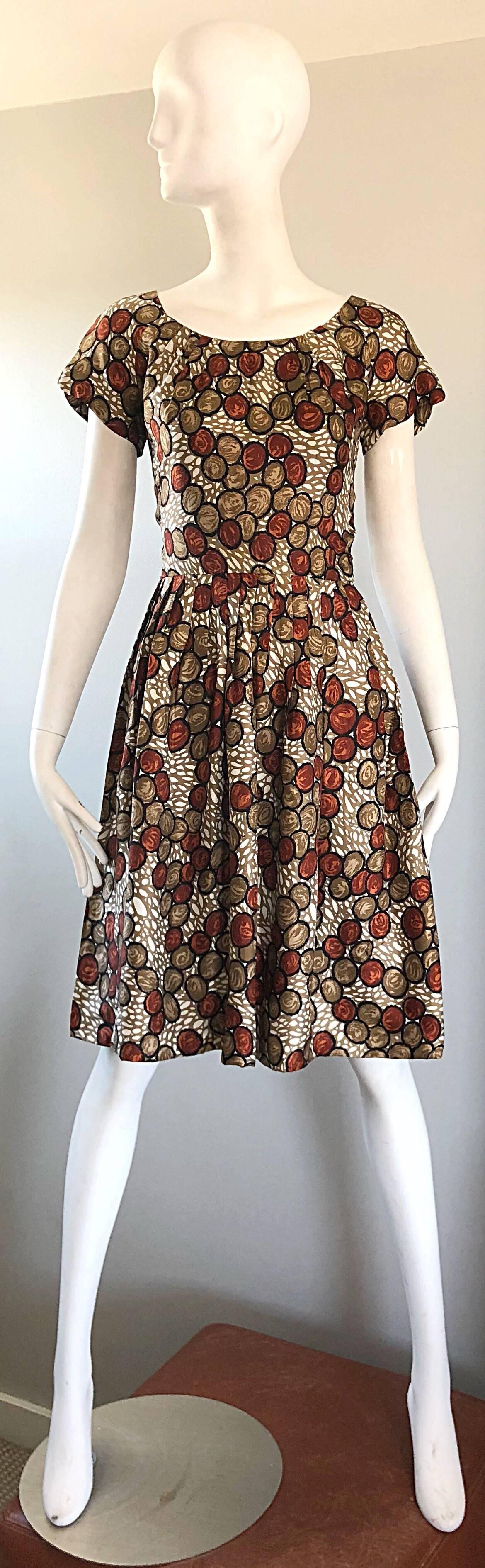 Gorgeous 1950s walnut novelty print fit and flare silk couture dress! Features a fun walnut print in rich rust brown, beige and ivory colors. Wonderful tailored fitted bodice with a forgiving and flattering full skirt. Full metal zipper up the back