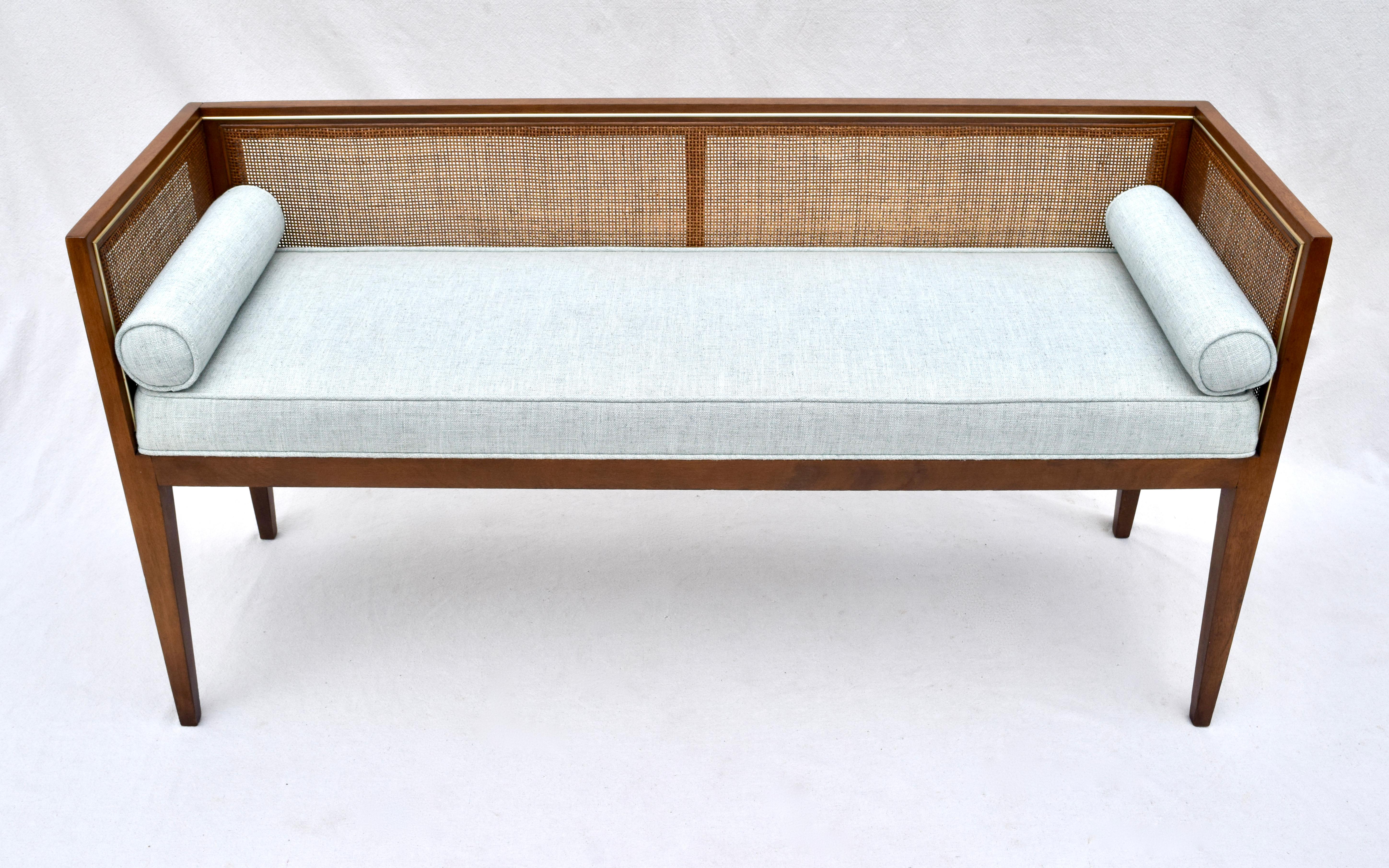 Solid walnut Mid-Century Modern window bench or settee attributed to Edward Wormley for Dunbar. Lithe line design constructed of walnut frame with original fine scale caning and subtle inlay brass bead accent to the interior surround. Fully detailed