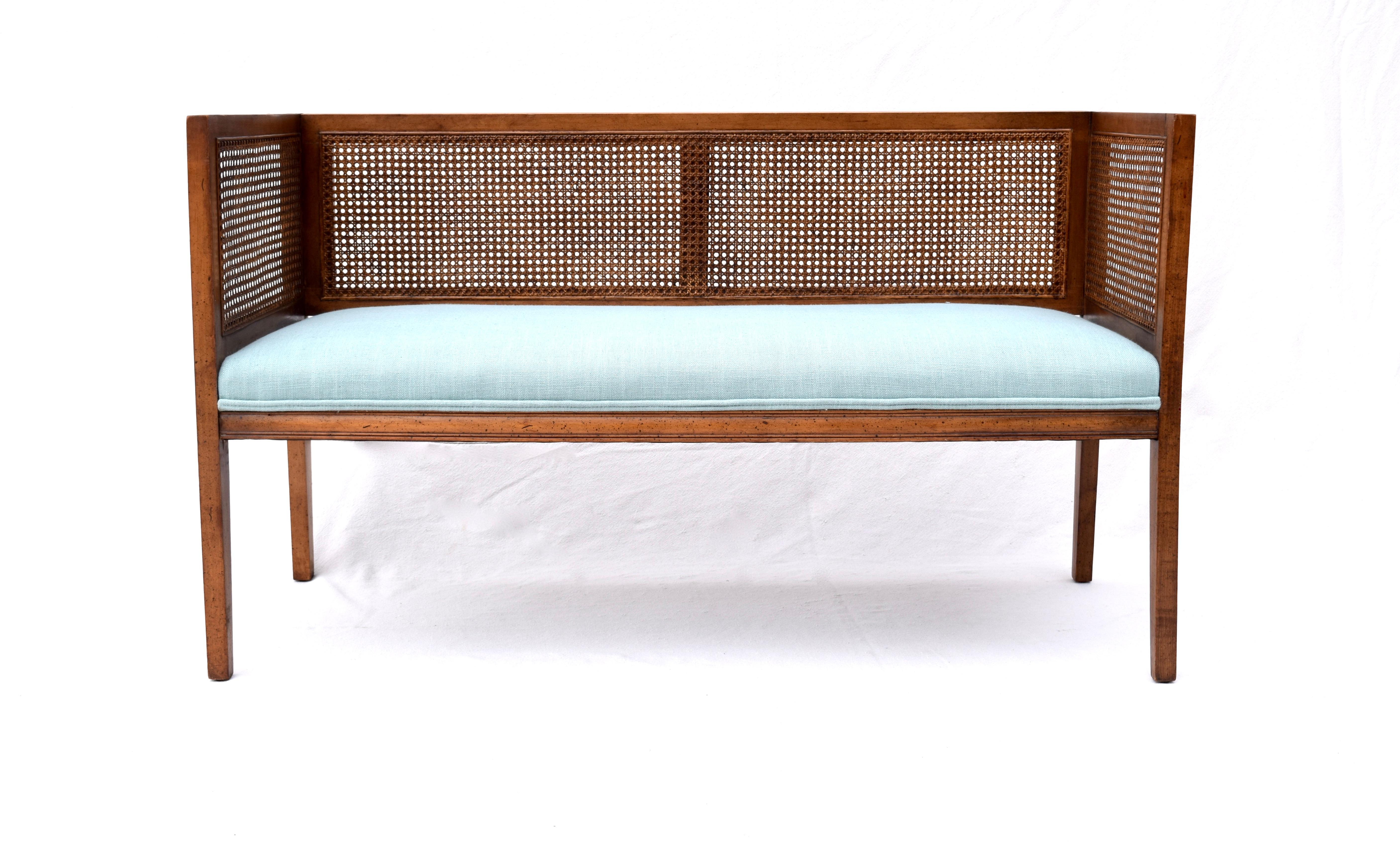 Solid walnut Mid-Century Modern window bench or settee in the manner of Edward Wormley for Dunbar. Beautifully maintained all original caning & finish with warm patina. Restored seat and bolster cushions are upholstered is soft blue linen.