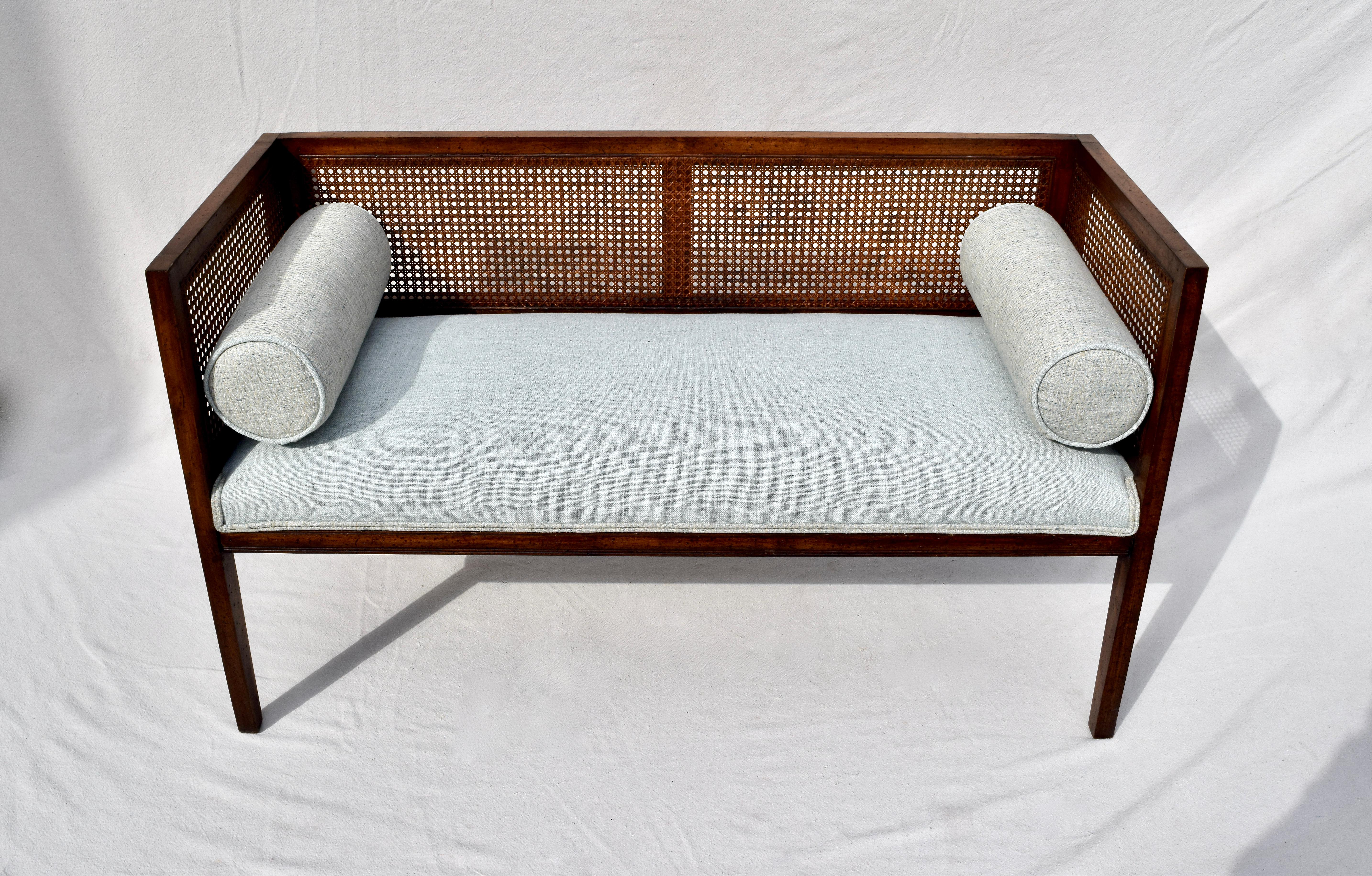 Solid walnut Mid-Century Modern window bench or settee in the manner of Edward Wormley for Dunbar. Beautifully maintained all original caning and finish with warm patina. Restored seat and bolster cushions are upholstered is soft blue linen.