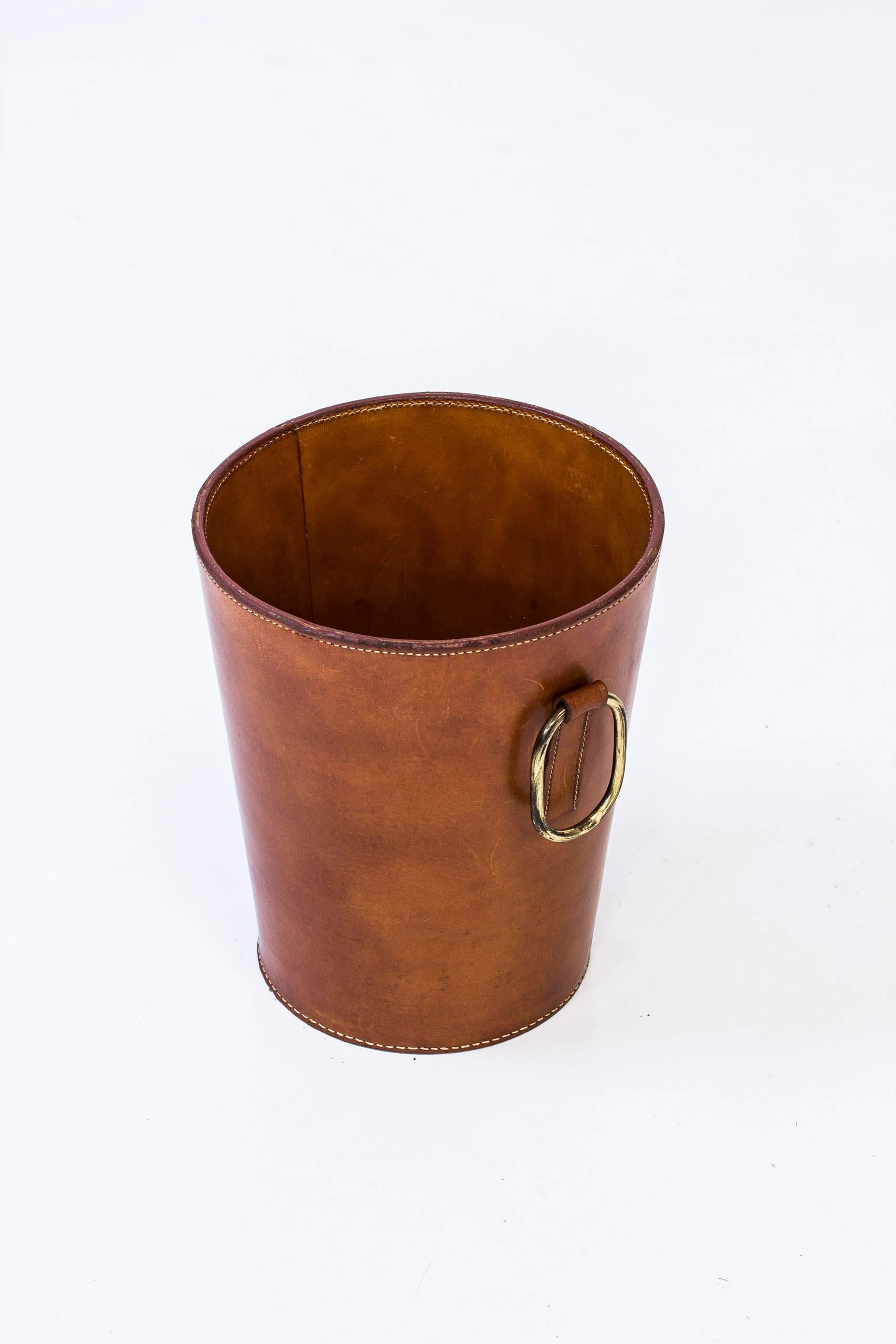 Waste paper basket designed by Carl Auböck. Handmade at his own workshop in Vienna, Austria. Made from two layers of thick natural leather. Hand-sewn together and decorated by a large brass hoop. Leather with perfect patina and all seams intact.
