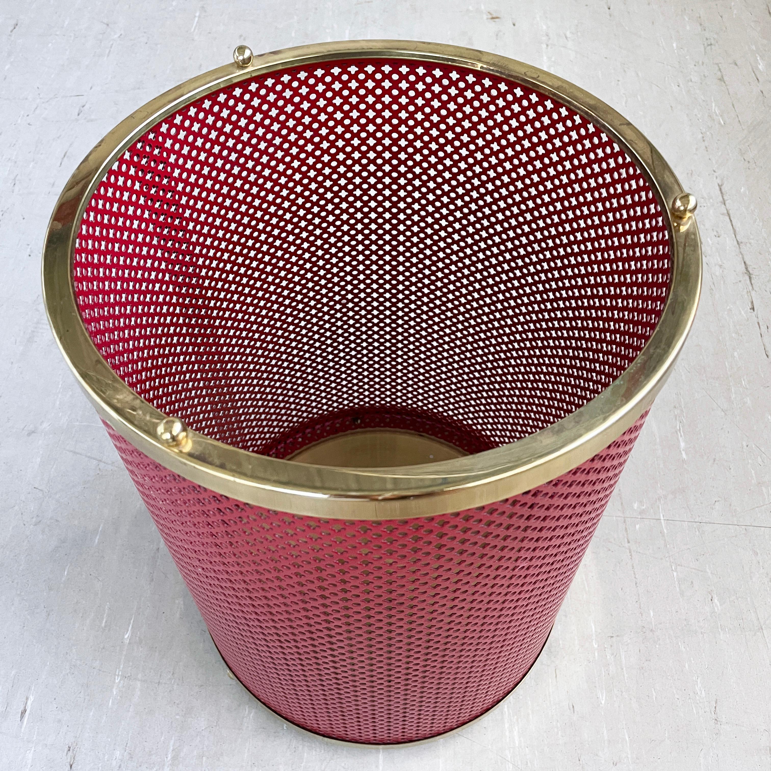 Corbeille à papier élégante du milieu du siècle. Fabriqué à partir d'un revêtement en poudre rouge.  métal perforé avec base et détails en laiton. Le fabricant n'est pas confirmé, mais on pense qu'il est d'origine italienne.
Dimensions : Hauteur