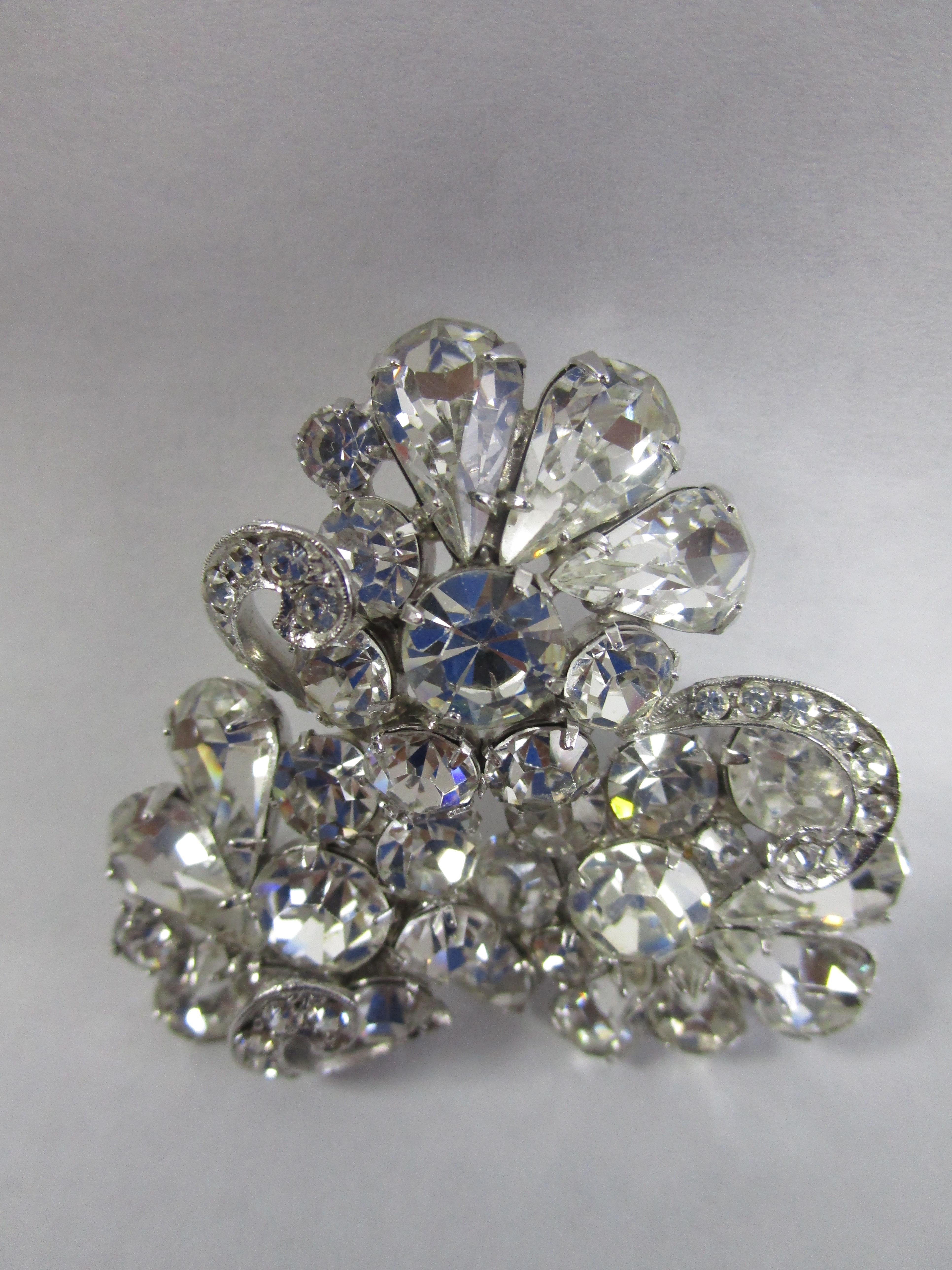 Weiss Swirled Tri Cluster Clear Crystal Brooch. Take a look at this large artfully made brooch from Weiss!
It features three clusters of rhinestones in various cuts and is a perfect sparkling addition to any outfit!

Albert Weiss started his own