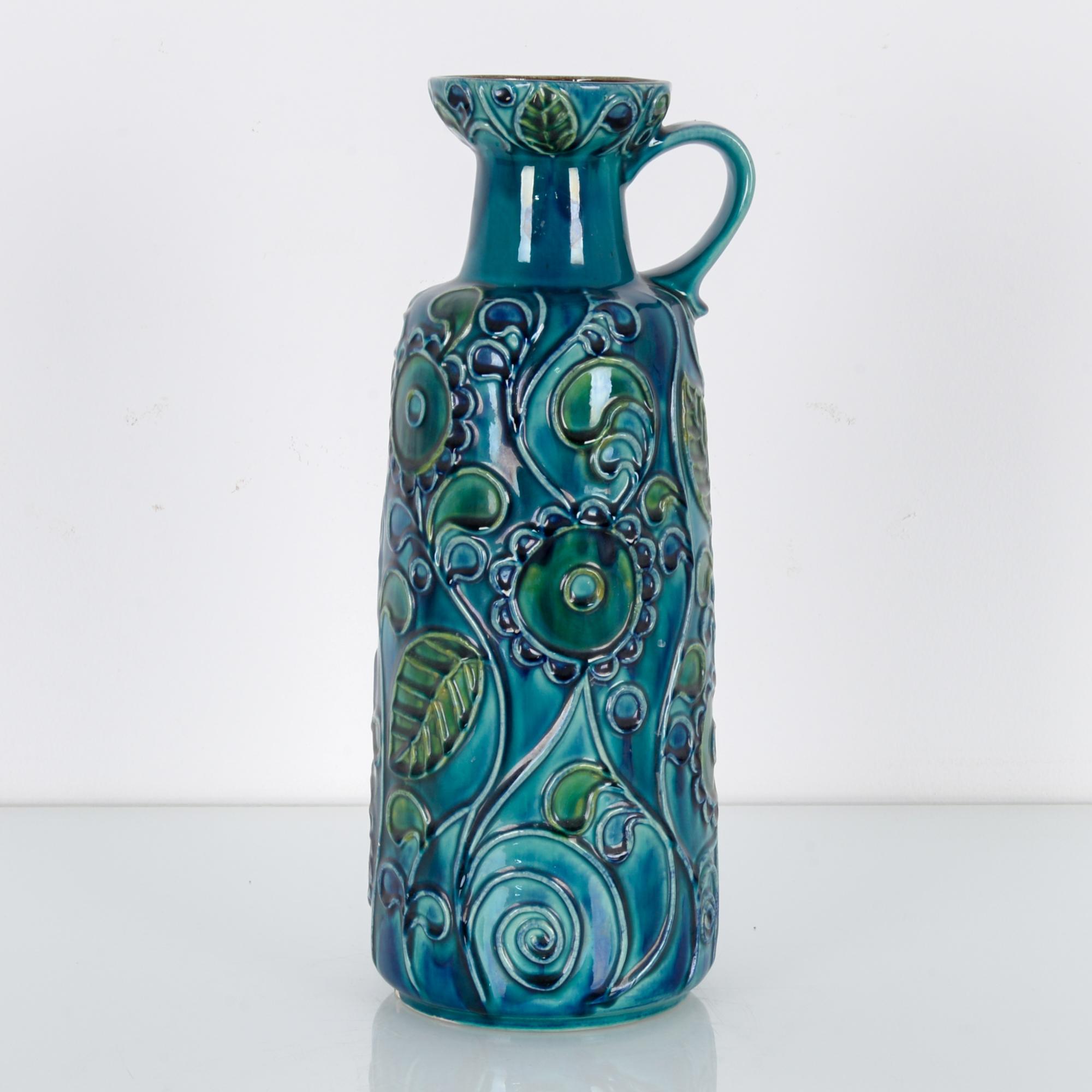 A blue ceramic vase produced by Bay Keramik in West Germany, circa 1950. This 45 cm patterned vase is glazed in a thick blue gradient, characteristic of the midcentury movement in West German ceramics. It seems to be flowing with its vegetative