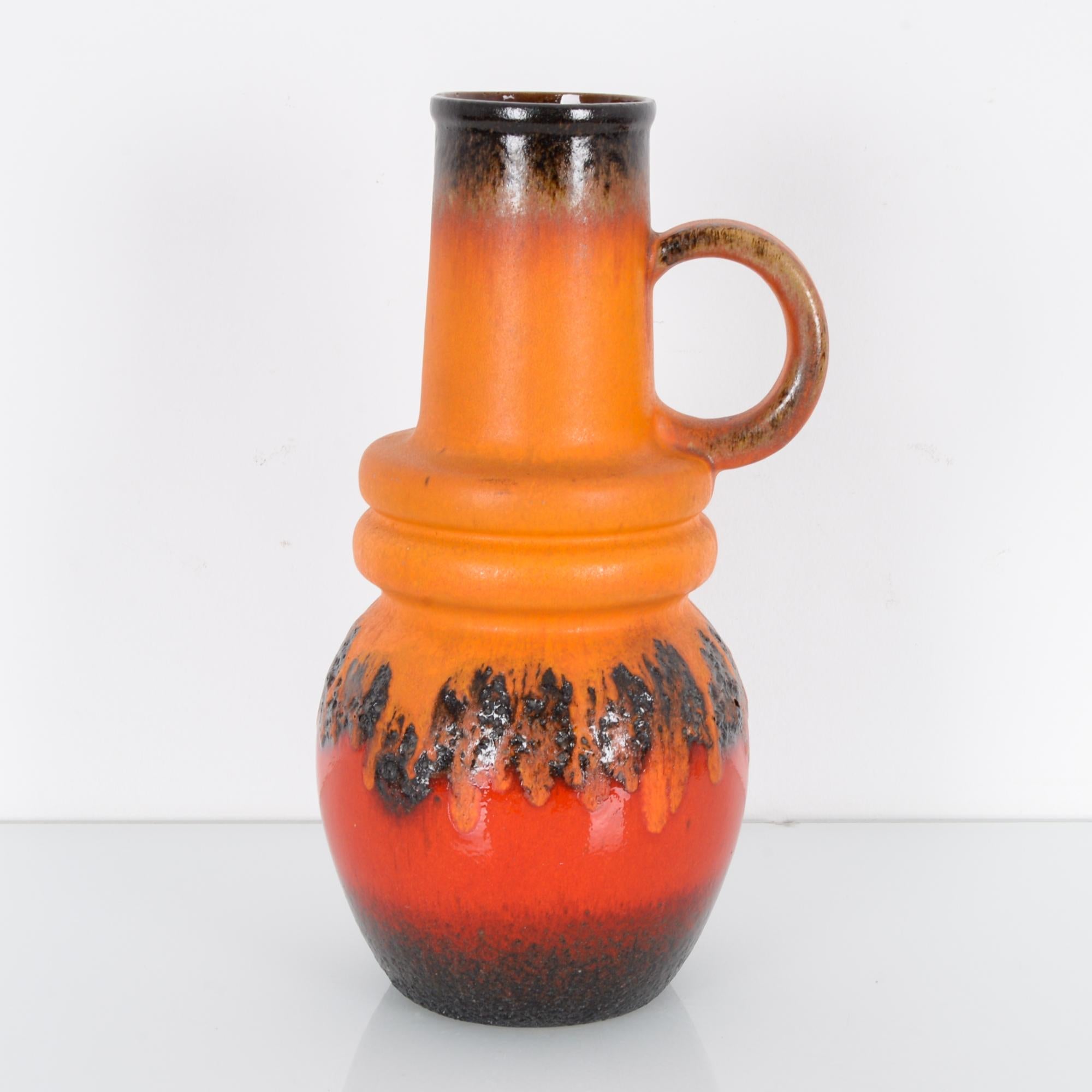 A 50 cm ceramic vase in vibrant orange-red glaze produced in West Germany, circa 1950. West German art pottery focused on single decorative pieces like vases and jugs, rather than sets of tableware, which gives each piece a feeling of having its own