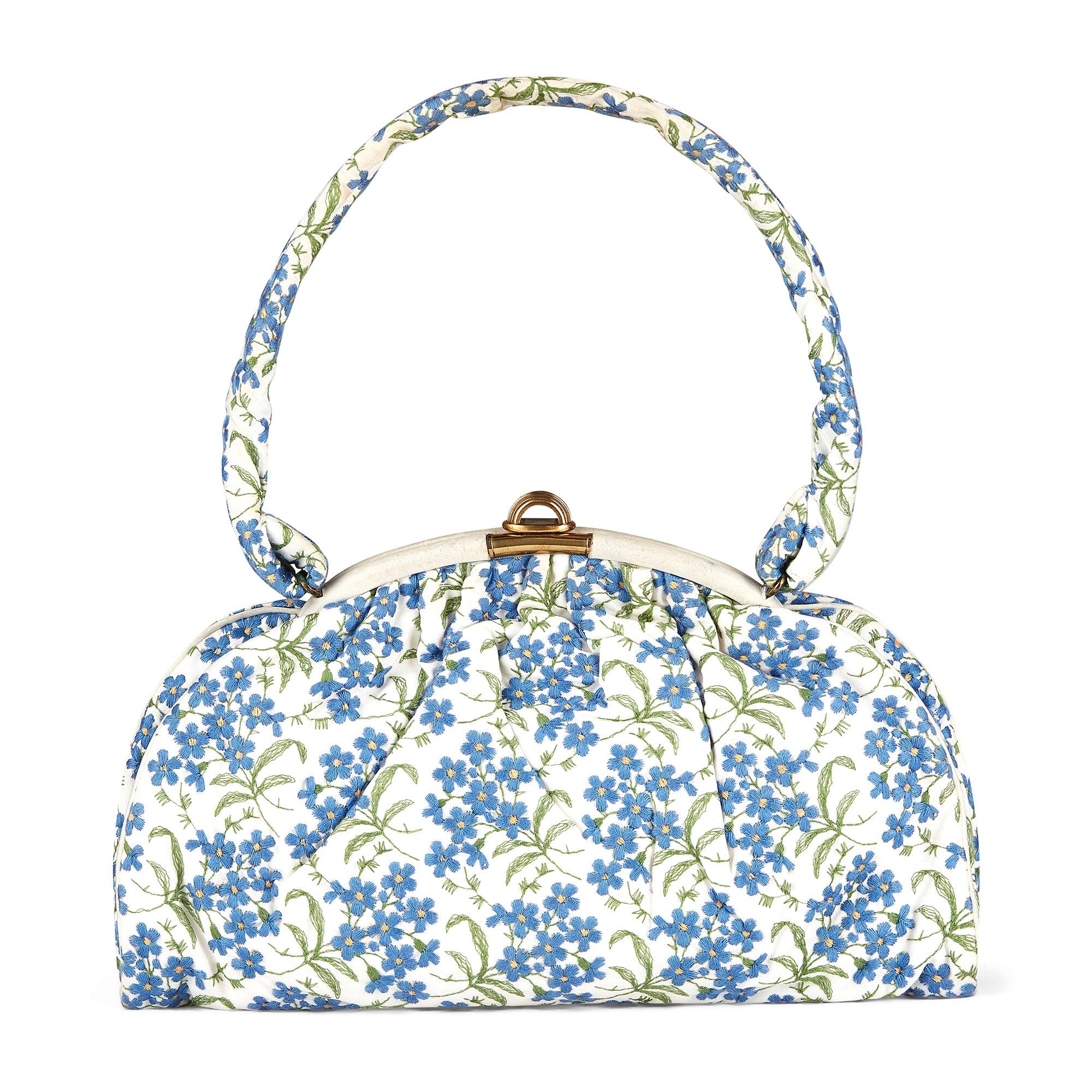 This delightful 1950s French couture top handle bag and glove pairing are a sweet combination.  Most likely made to complete a haute couture outfit, they are, alas, without labels. Crafted from white cotton, the pouch-like bag is embroidered all