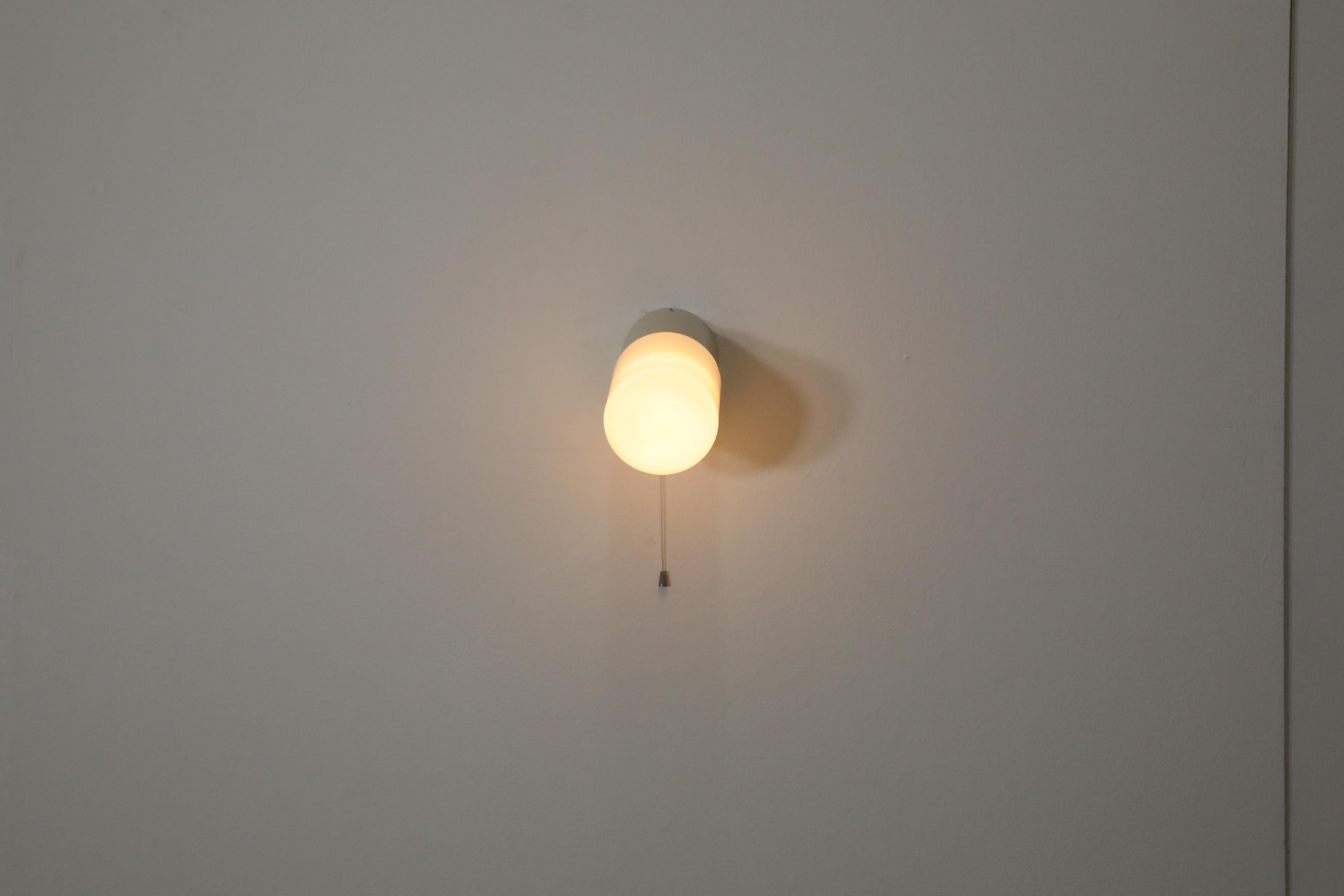 Olandese Lampada da parete cilindrica bianca degli anni '50 con base in bachelite color crema e interruttore a pulsante in vendita
