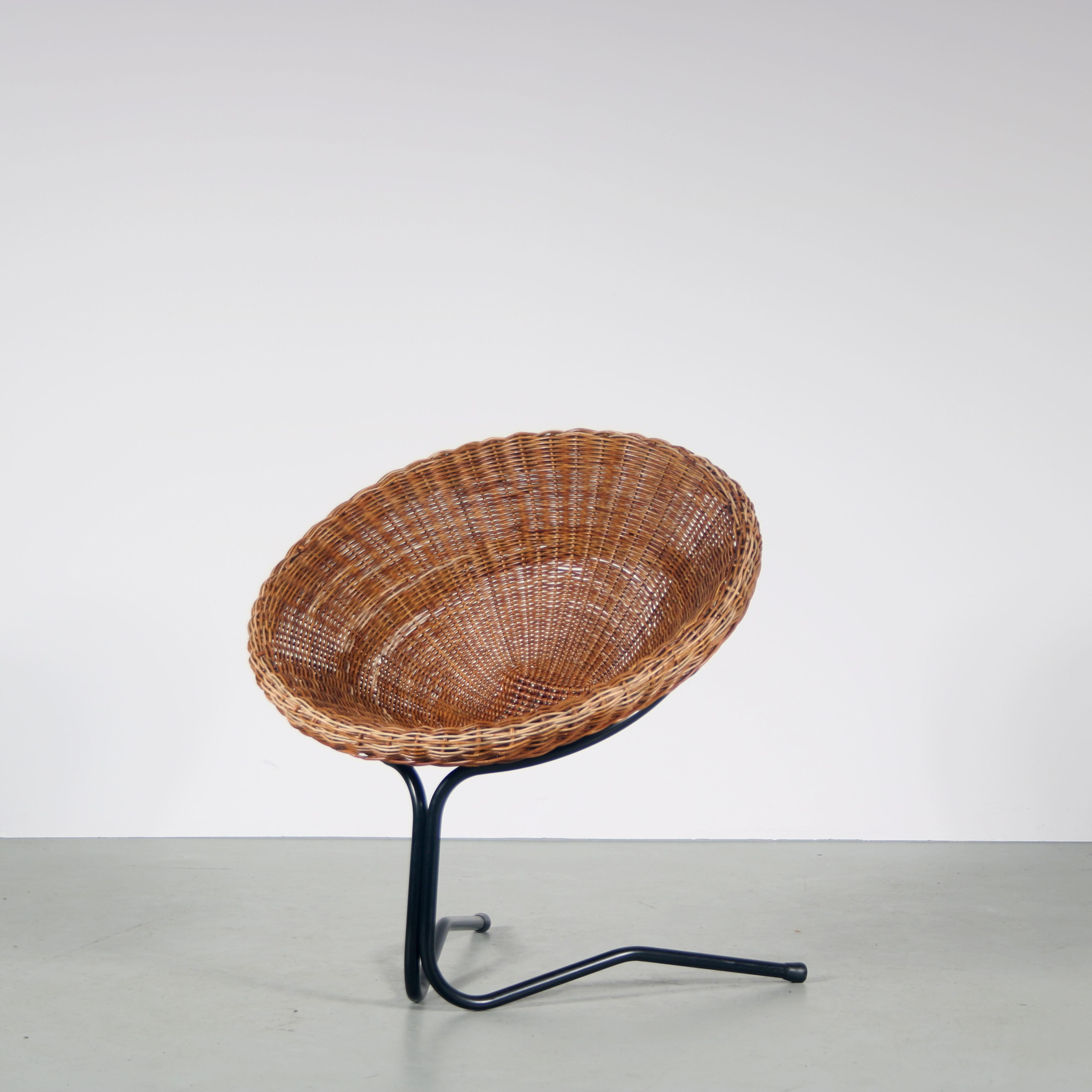 A lovely easy chair desigend by A. Bueno de Mesquita, manufactured by Rohé in the Netherlands around 1950.

This eye-catching piece has a round seat, standing on a V-shaped, black lacquered tubular metal base. The wicker shell rests in the round