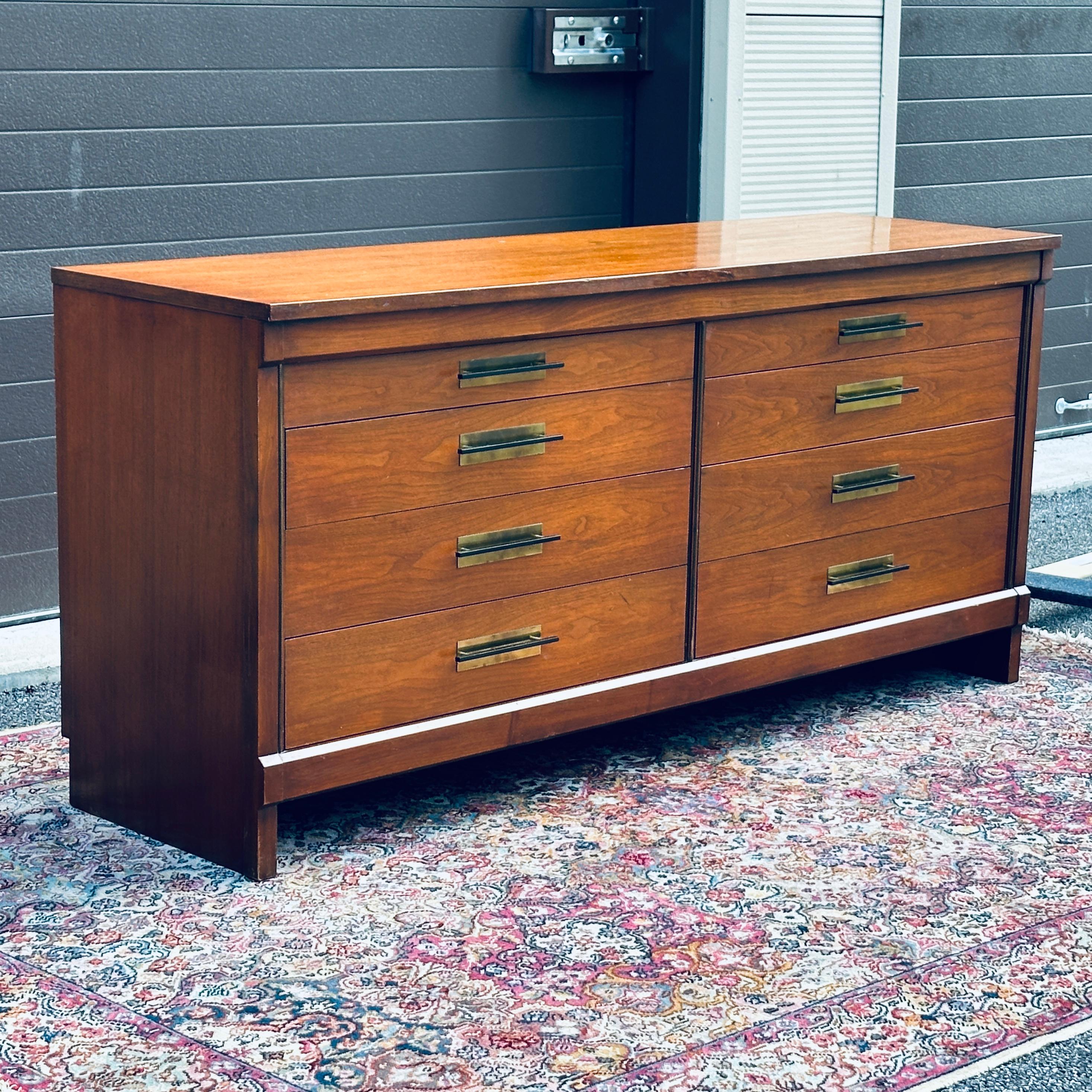 1950's Mid-Century Modern Widdicomb Credenza or Lowboy Dresser with interesting large scale brass and black enamel drawer pulls and vertical brass trim detail on either side of drawers. Eight dovetailed drawers on metal side tracks. Some drawers