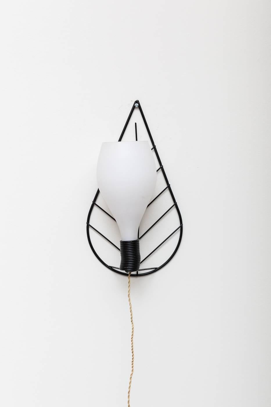 Black enameled metal wire leaf-shaped wall mount frame with bulbous satin milk glass shade. In original condition with original hardware and twisted wire, new plug.