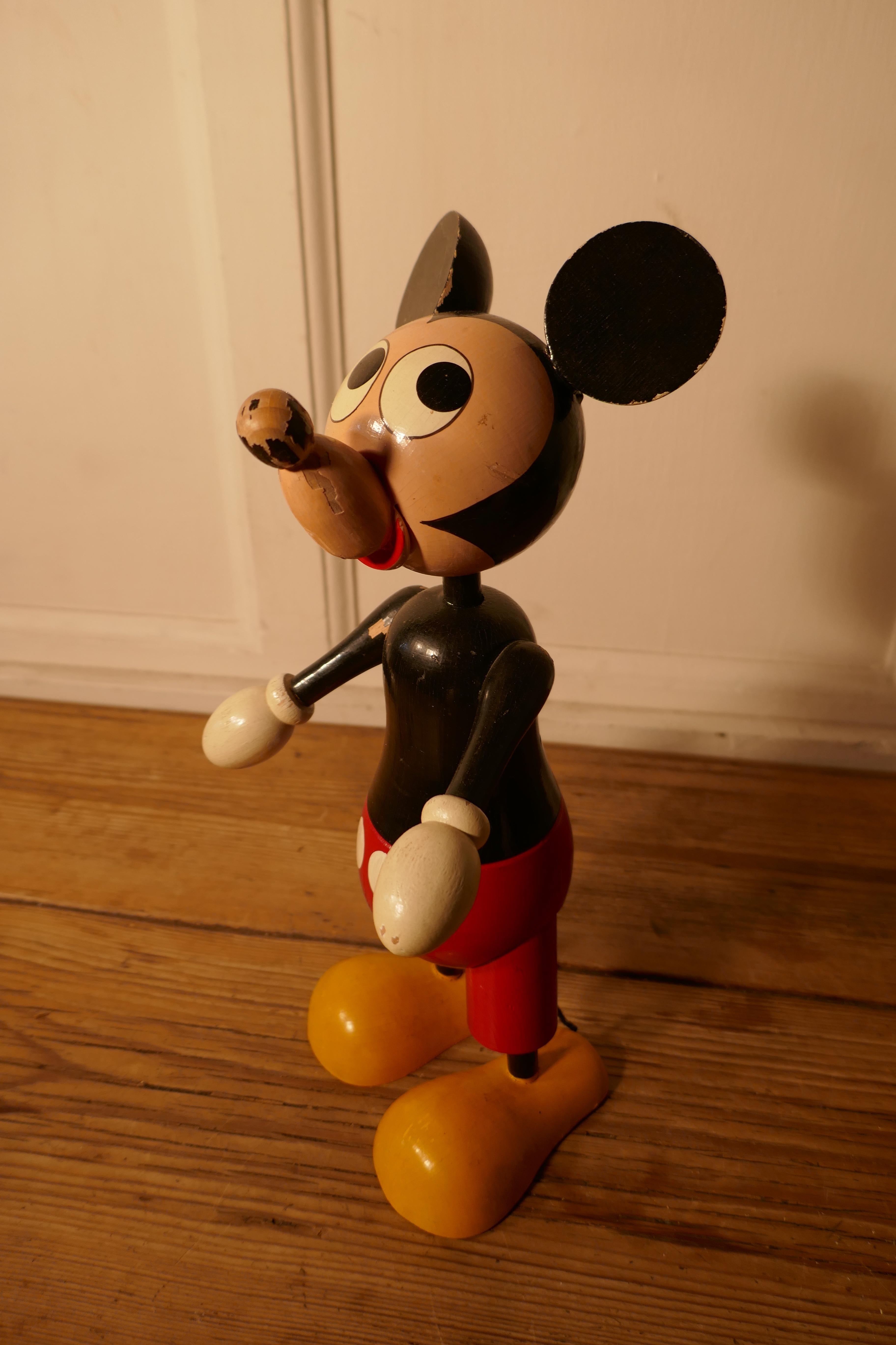 1950s wooden disney Mickey Mouse money box

A rare collectable from around 1950, with a coin slot in his back 
This very desirable money box opens in the middle it is locked by means of a tiny pad lock
The condition is sound with minor wear to