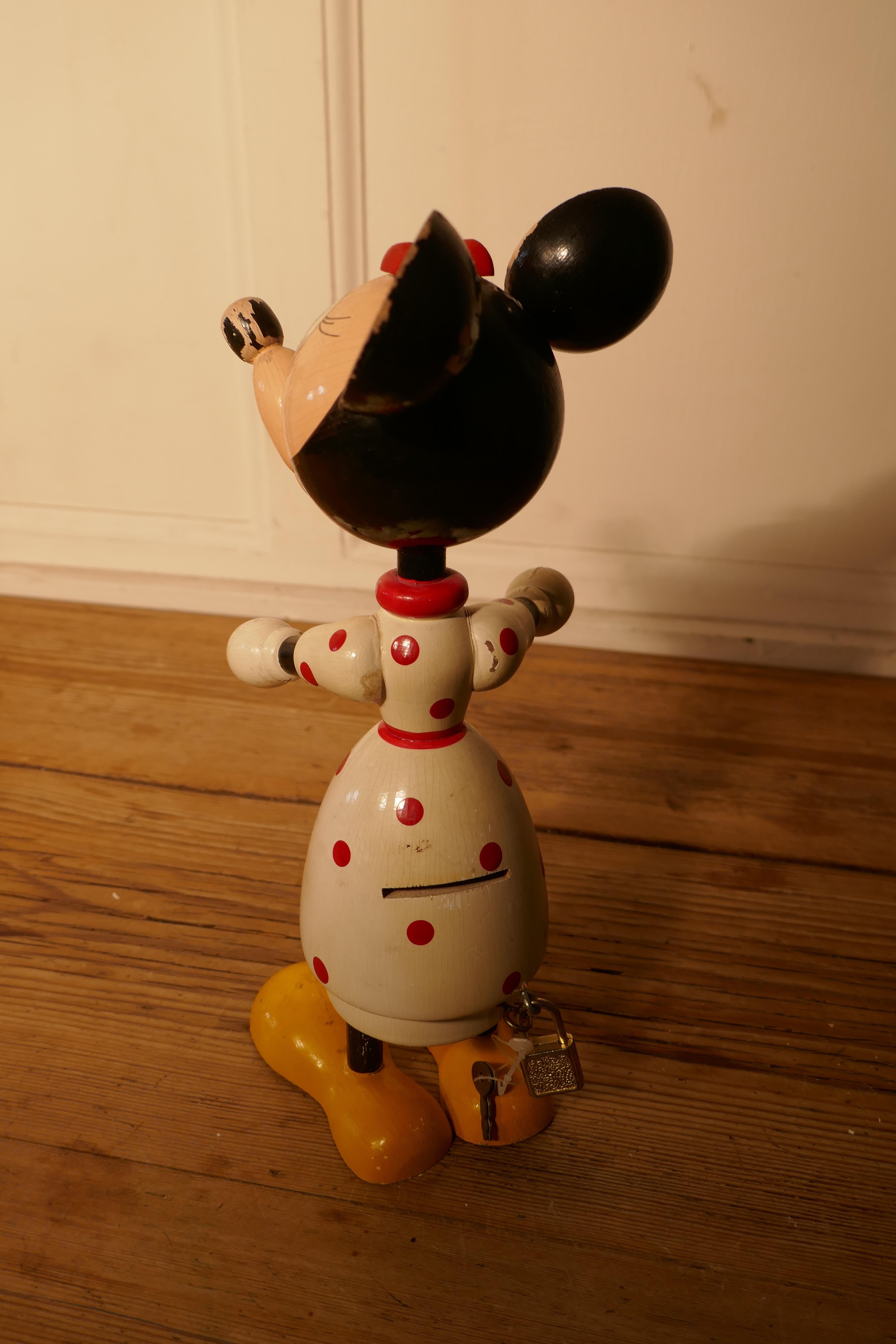 1950s wooden disney mini mouse money box

A rare collectable from circa 1950, with a coin slot in her back 
This very desirable money box opens in the middle it is locked by means of a tiny pad lock
The condition is sound with minor wear to the