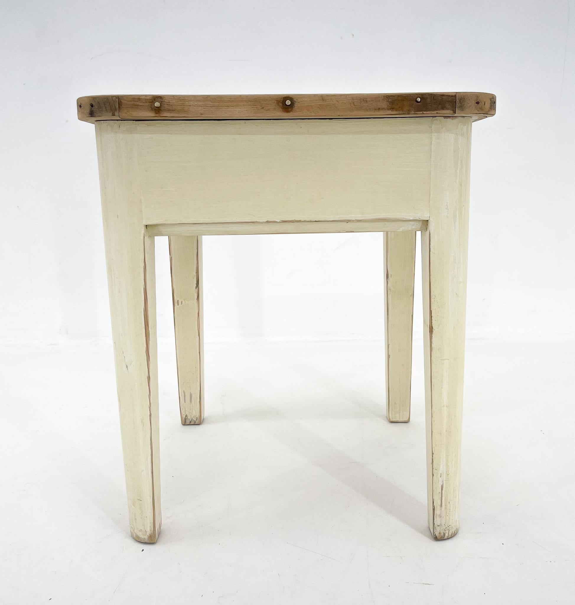 An all-wood stool from the 1950s with a hinged top with storage space underneath. All parts are original, including the paint on its bottom. Only the top has been sanded down.