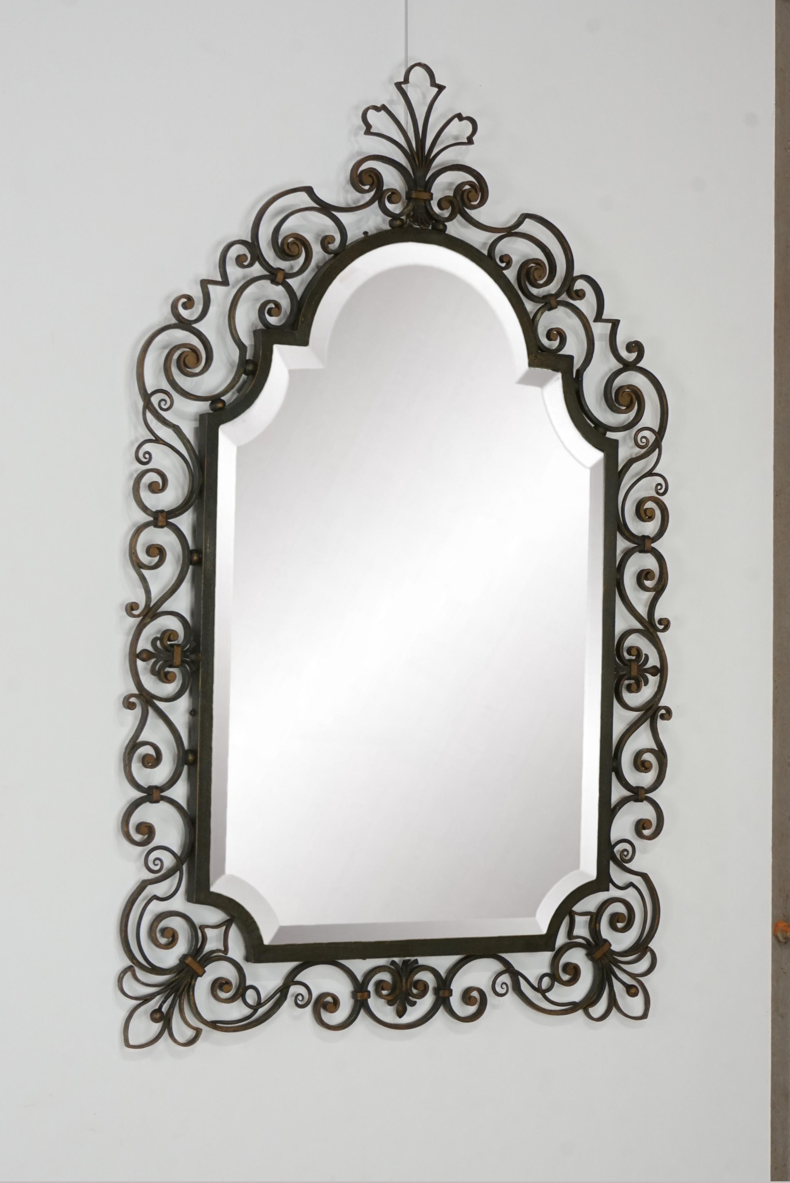 Elegance and beautiful patina for this mirror of the 1950s with black and gild finish wrought iron structure, beautifully crafted adorning a beautiful beveled mirror
