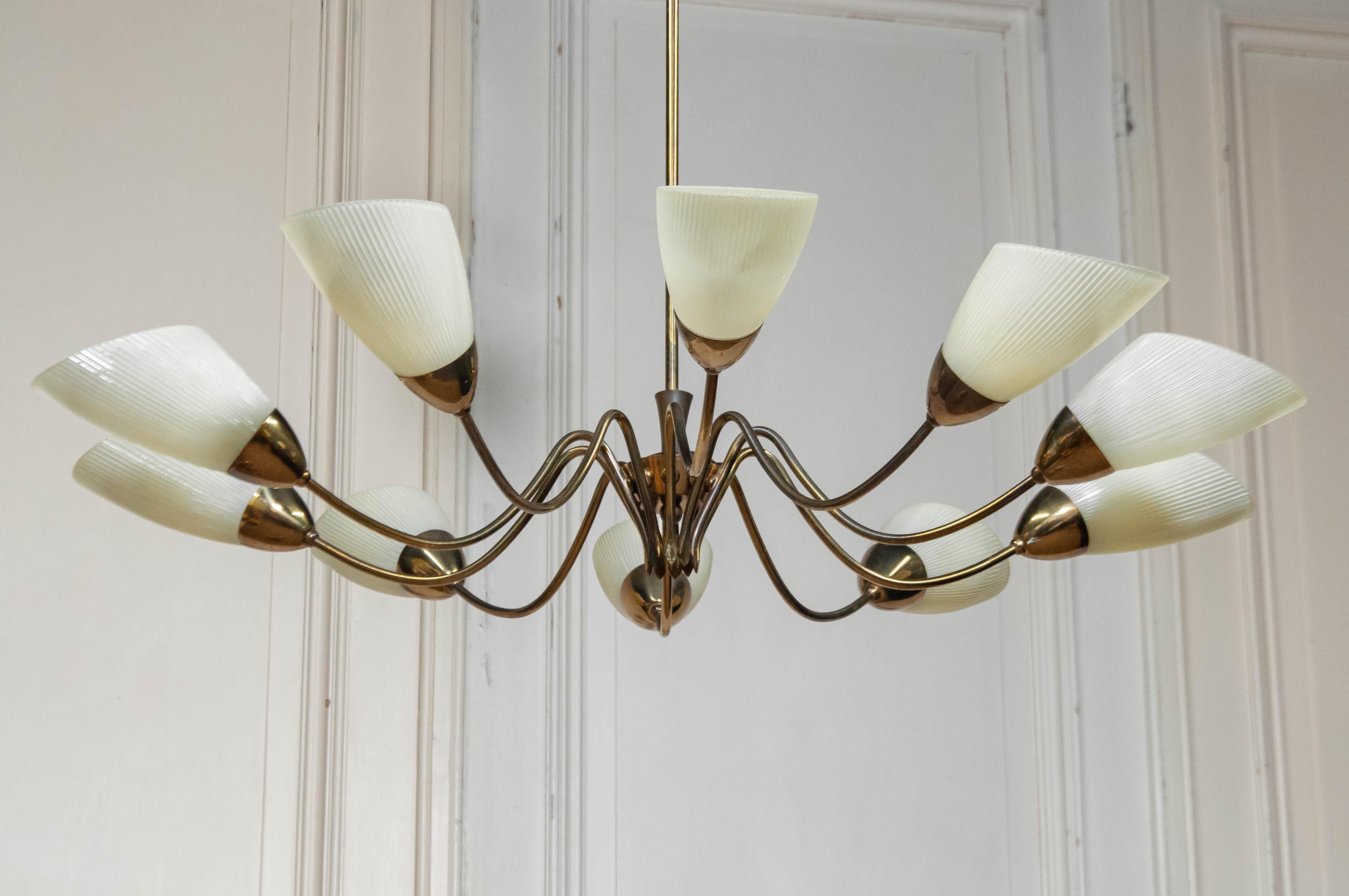 This stunning mid-century XL chandelier is attributed to Angelo Lelii for Arredoluce, an iconic Italian lighting manufacturer. Designed in the 1950s, this chandelier features a distinctive Sputnik-inspired brass frame, elegantly curved arms, and 10