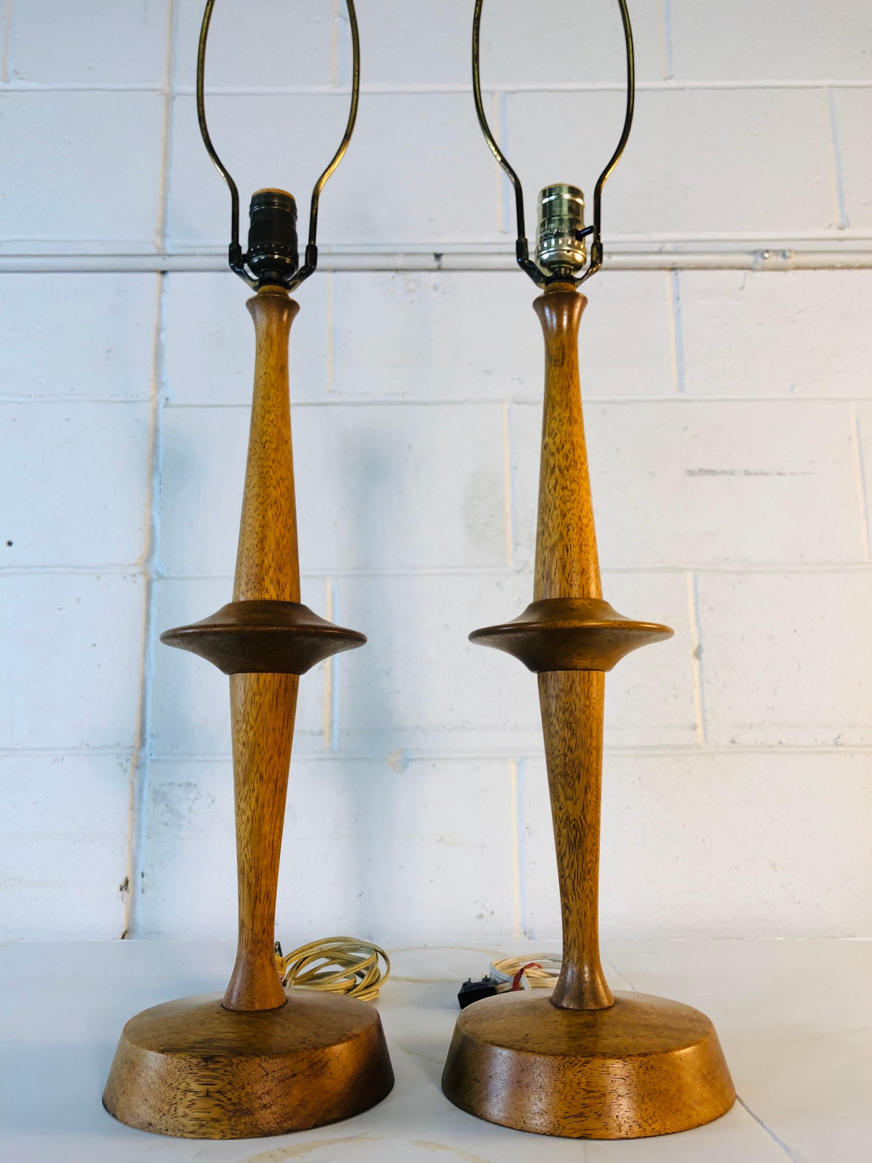 Vintage 1950s pair of Yasha Heifetz Atomic-style table lamps in bleached mahogany. These turned wood lamps have a great round atomic style accent in the middle of the lamp. Both lamps are in original condition and are signed. Socket, 22.5” height.