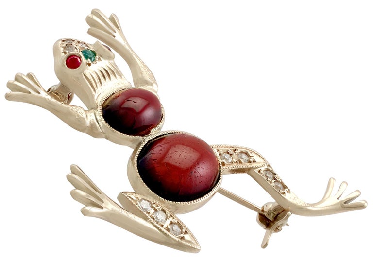 A fine and impressive 0.22 carat diamond. 5.95 carat garnet, 0.10 carat ruby and emerald, and 14 karat yellow gold 'frog' brooch; part of our diverse vintage jewelry collections

This fine and impressive vintage cabochon cut frog brooch has been