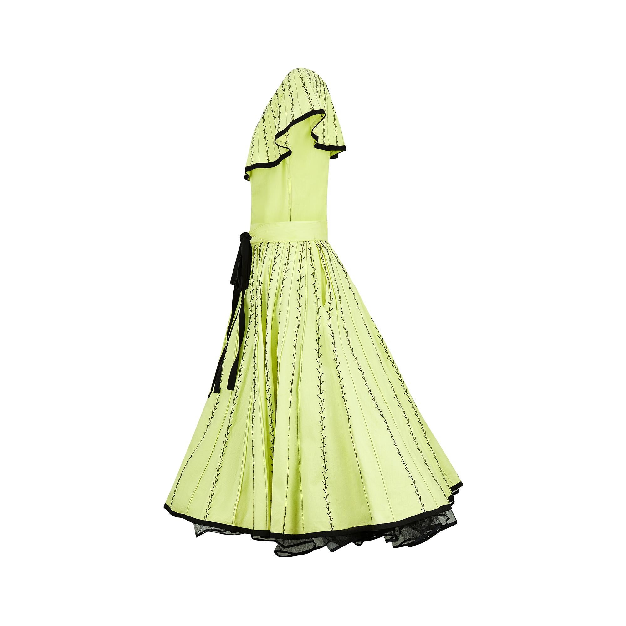 This striking two-piece ensemble was crafted in Mexico in the 1950s. The cotton fabric is a vibrant lime-yellow, almost neon, and as luminous as the day it was made. Composed of an off-shoulder top and voluminous below the knee-length skirt, these