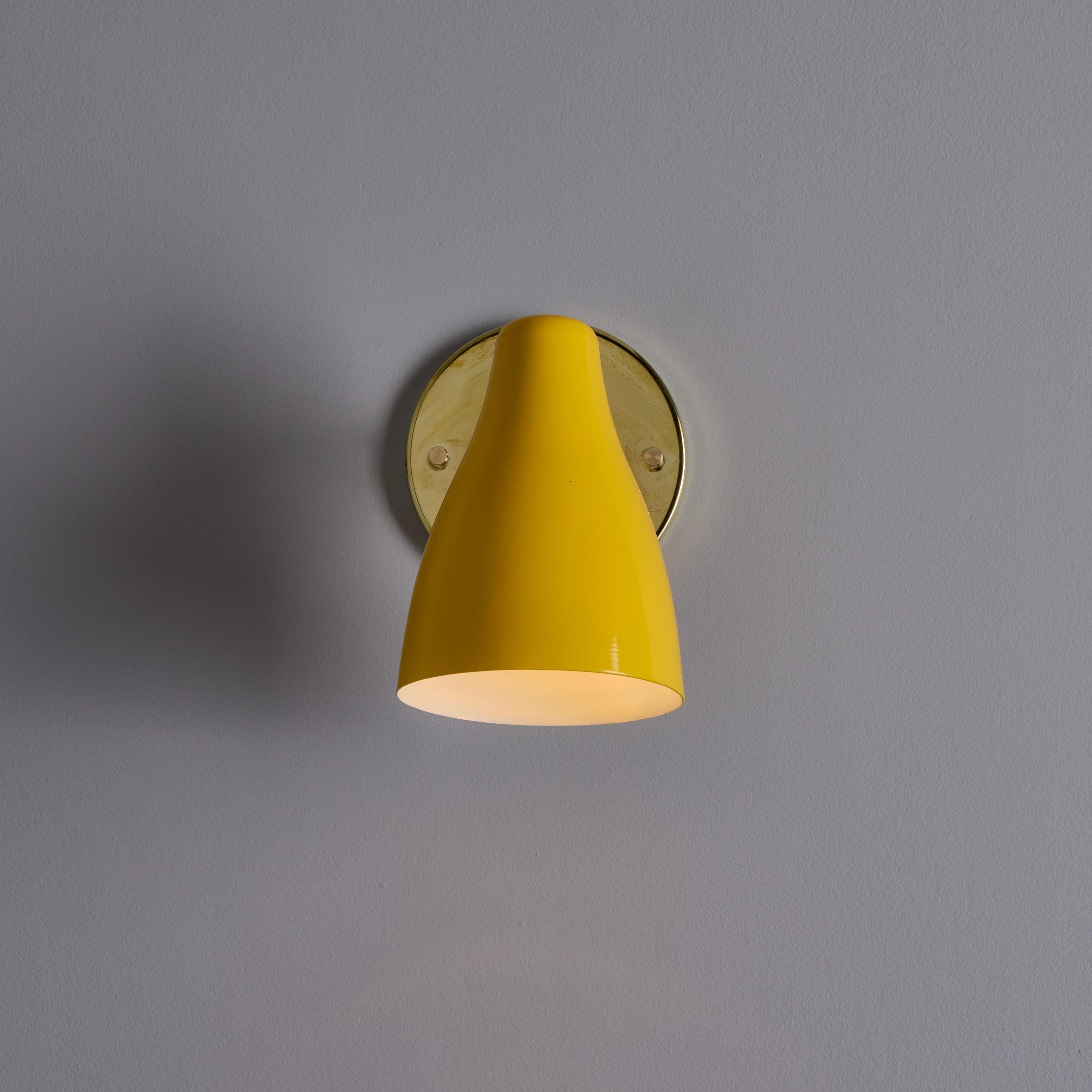 1950s Yellow Painted Metal & Brass Wall Lamp Attributed to Stilnovo. 

Executed in bright yellow painted perforated metal shade with brass arm and backplate. The shade rotates freely left/right and up/down on a ball joint. A sculptural and refined