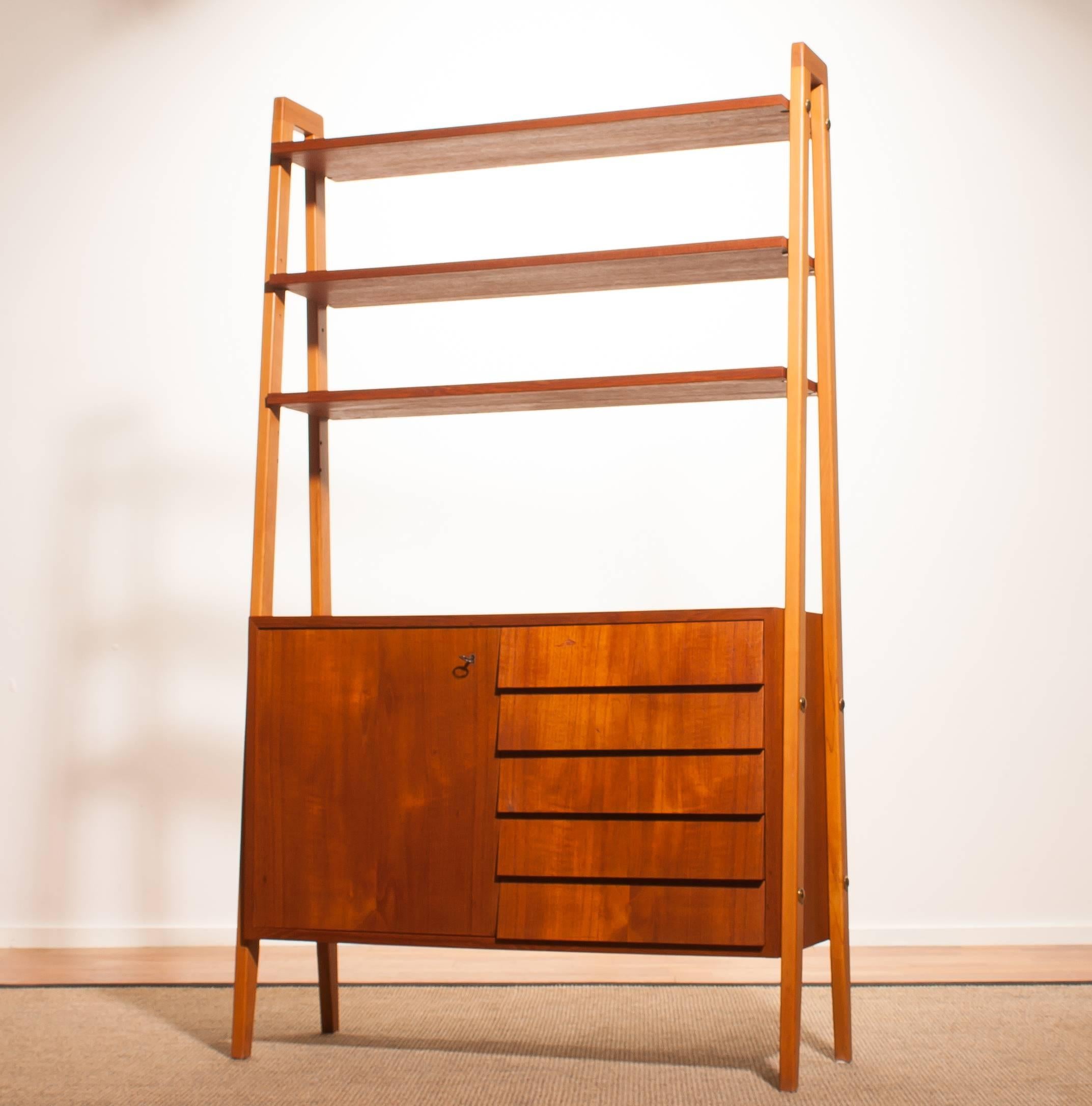 In excellent condition cabinet, room divider, bookcase in teak.
The stands are made of beech.
This cabinet has got five drawers, one door and three book shelves.
Period 1950s
Dimensions H 170 cm, W 100 cm, D 35 cm.

 