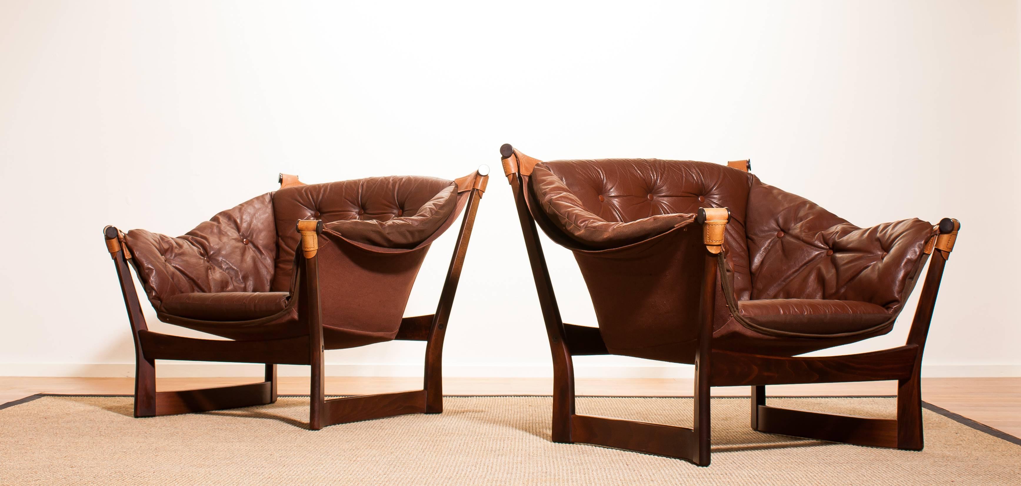 Very beautiful pair of Scandinavian modern easy chairs designed by Tormod Alnaes for Sørliemøbler Norway.
They feature a wooden frame and are upholstered in dark brown leather.
The condition of the chairs is very good and they are very