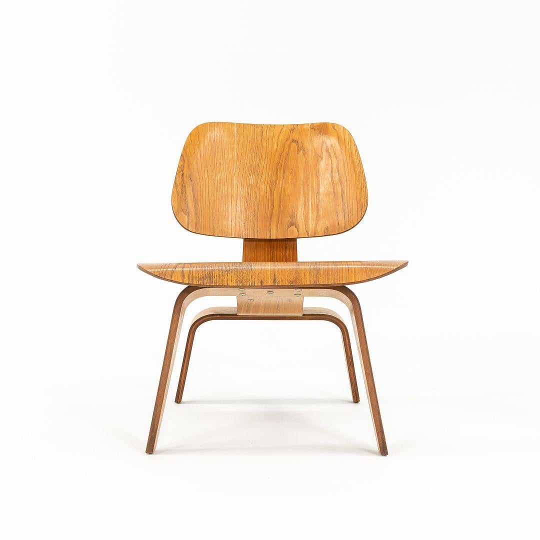 This is an early pair of LCW Lounge Chairs, originally designed by Charles and Ray Eames in 1945. The pair was produced circa 1951 by Evans Products Company for Herman Miller. One of the chairs retains its label, and they have the 5-2-5 screw