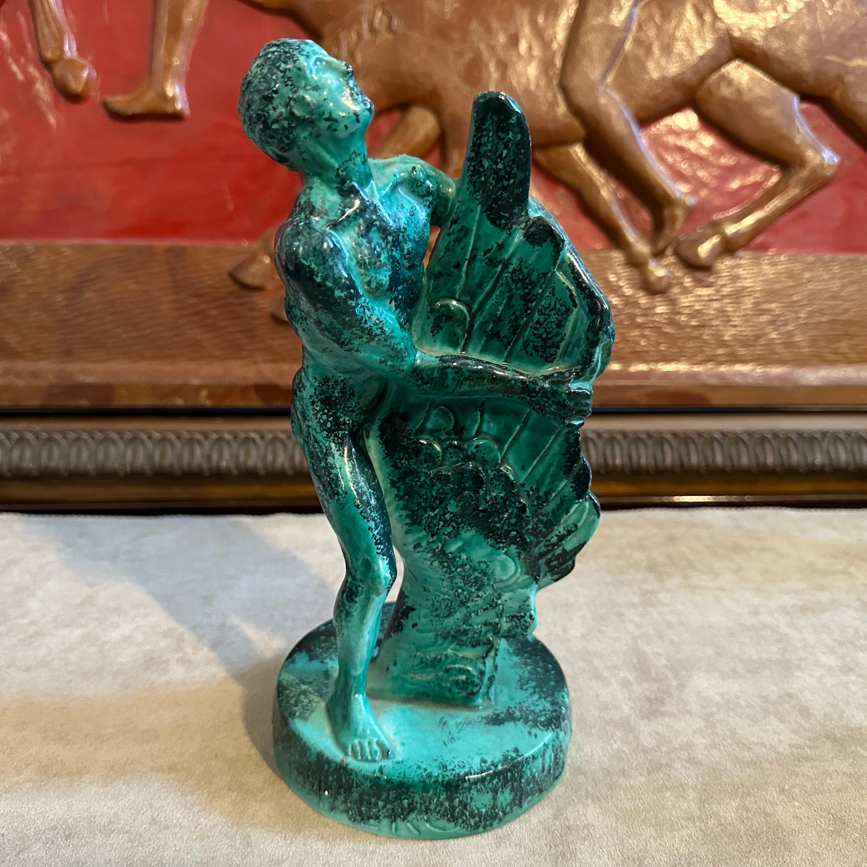 It's a green ceramic figure dated 8-9-1951, especially made for an aviation rally of  Aeroclub Vicenza. It's in perfect condition and depicts a stylized man holding a Wing. The figure has marked in relief on the base the date and Avioraduno Aeroclub