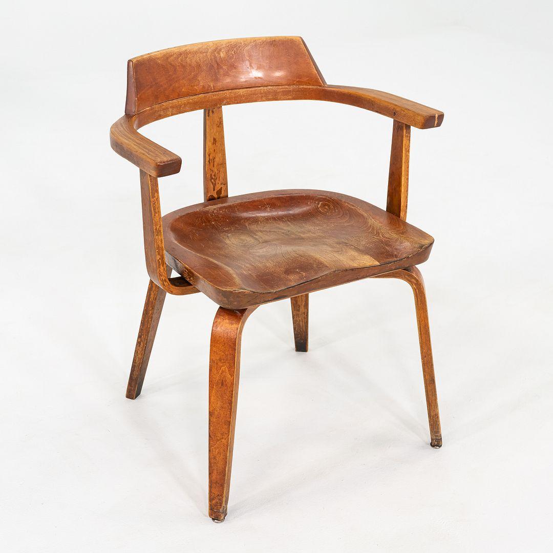 This is a W199 Dining Armchair, originally designed by Walter Gropius and Ben Thompson for Thonet in 1951. The chair was produced in Austria in the early 1950s. The design features bent birch plywood legs, arms, and back supports, and solid